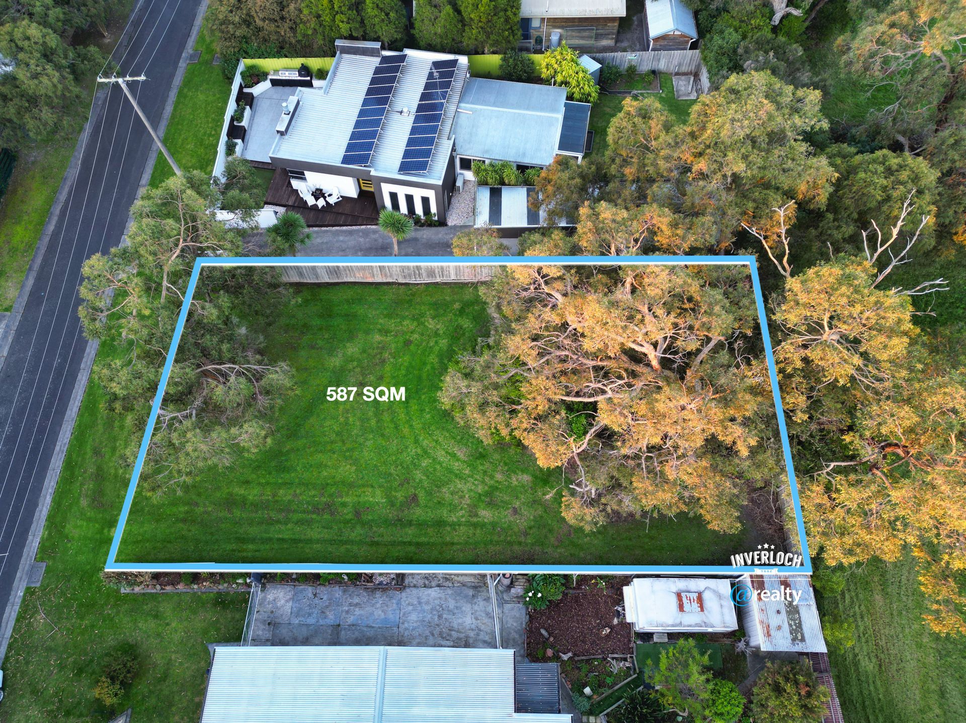 An aerial view of a residential area with a lot of grass and trees.