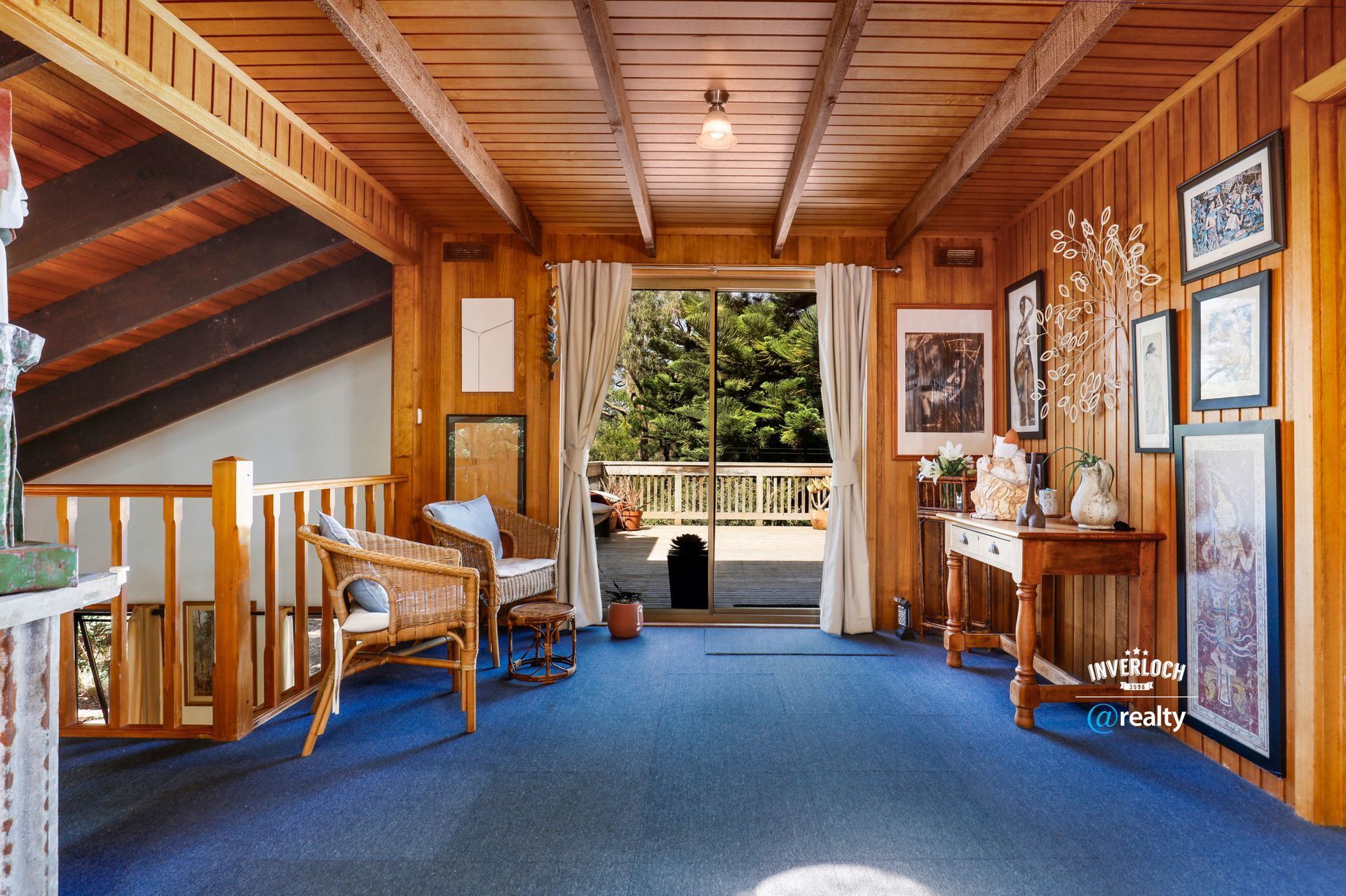 A living room with a wooden ceiling and blue carpet