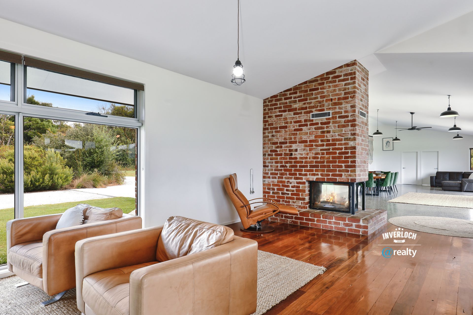 A living room with a brick fireplace and a couch and chairs