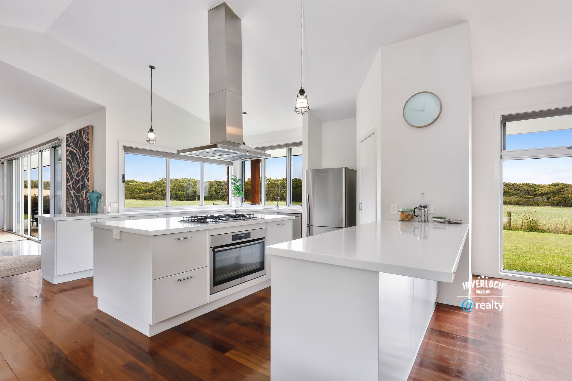 A kitchen with white cabinets , stainless steel appliances , and a large island.