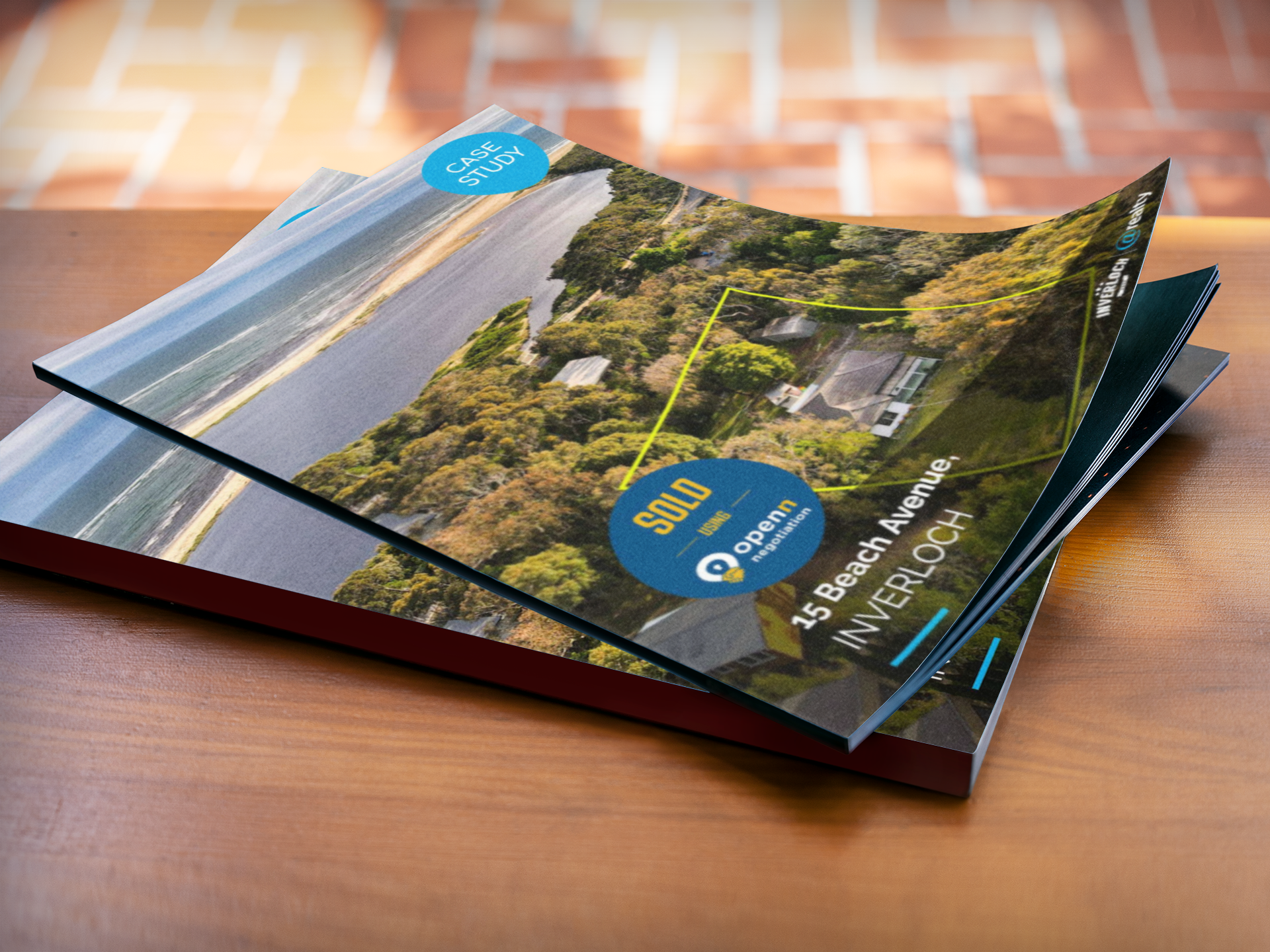 Two brochures are stacked on top of each other on a wooden table.