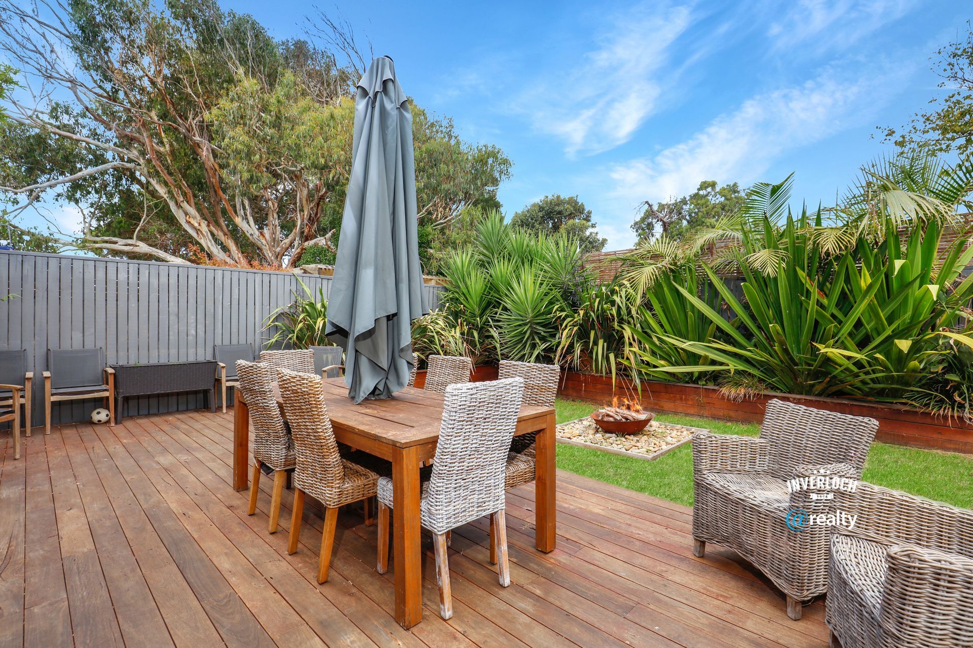 A wooden deck with a table and chairs and an umbrella