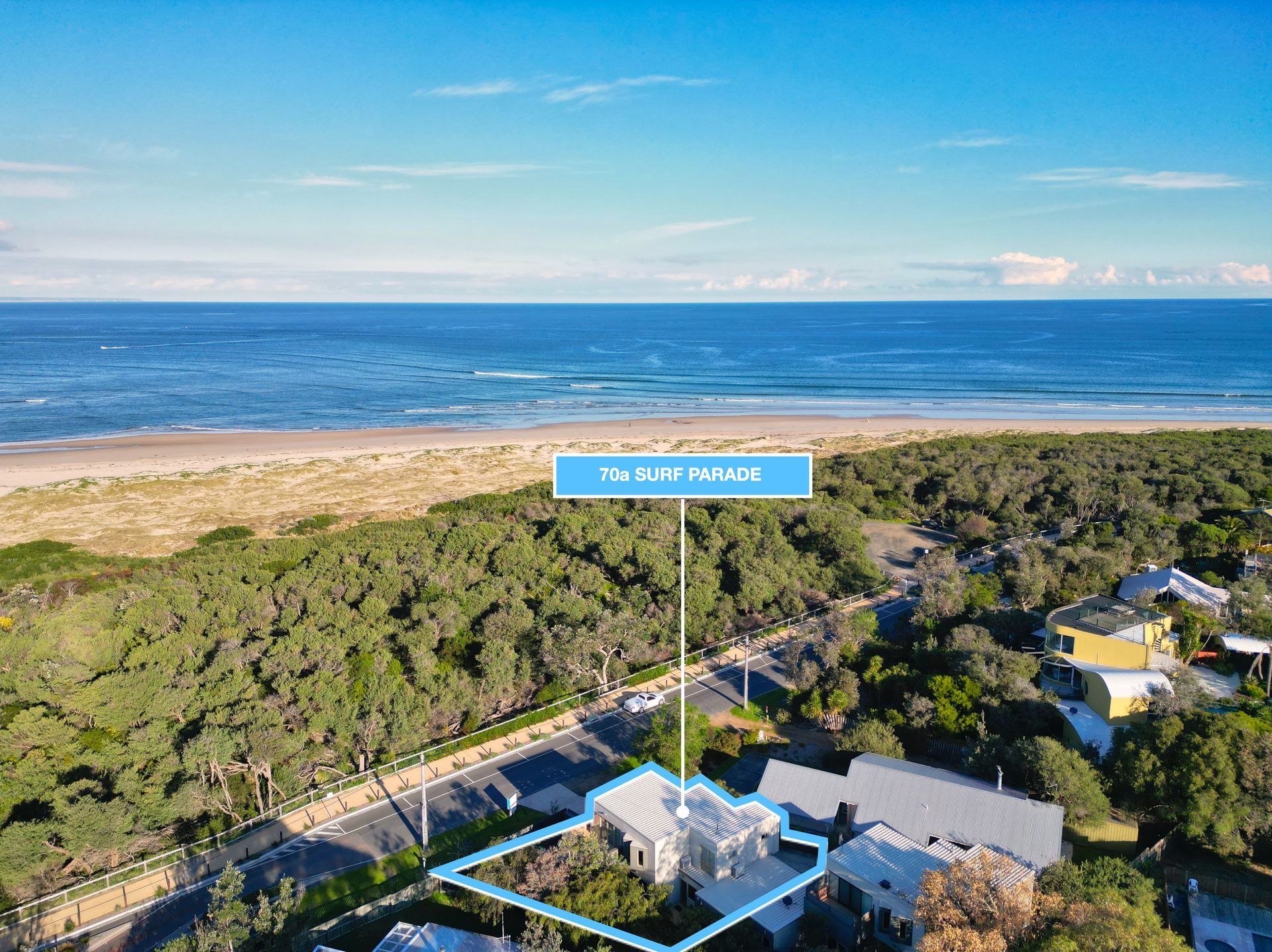 An aerial view of a residential area with a beach in the background.