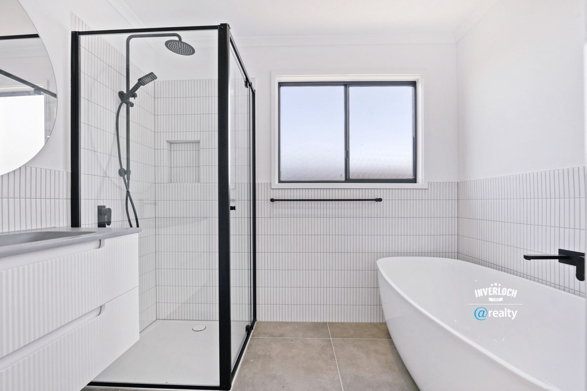 A bathroom with a bathtub , sink , shower and window.