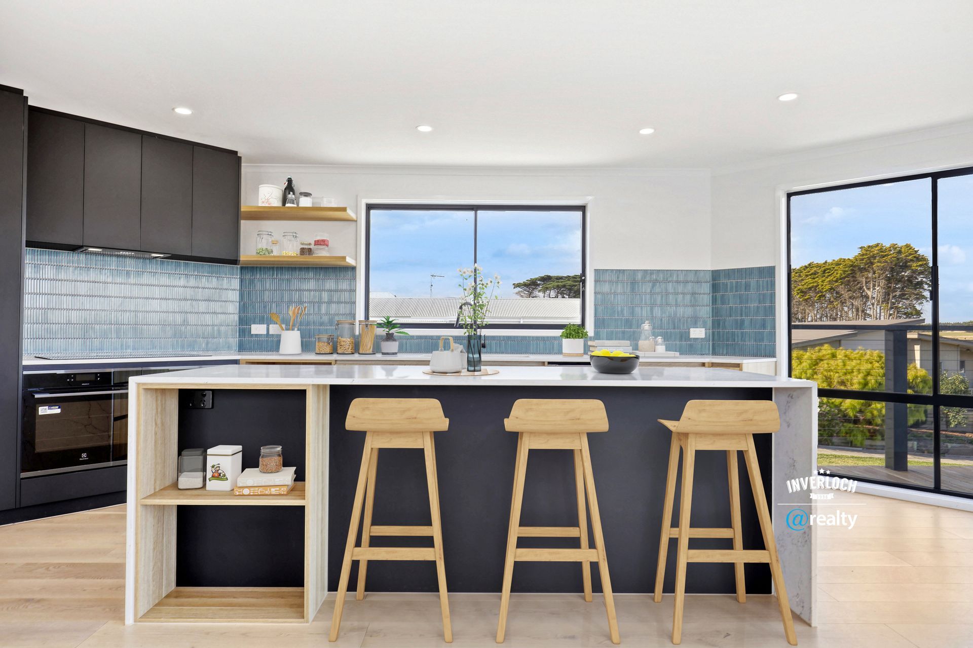 A kitchen with a large island and three stools.