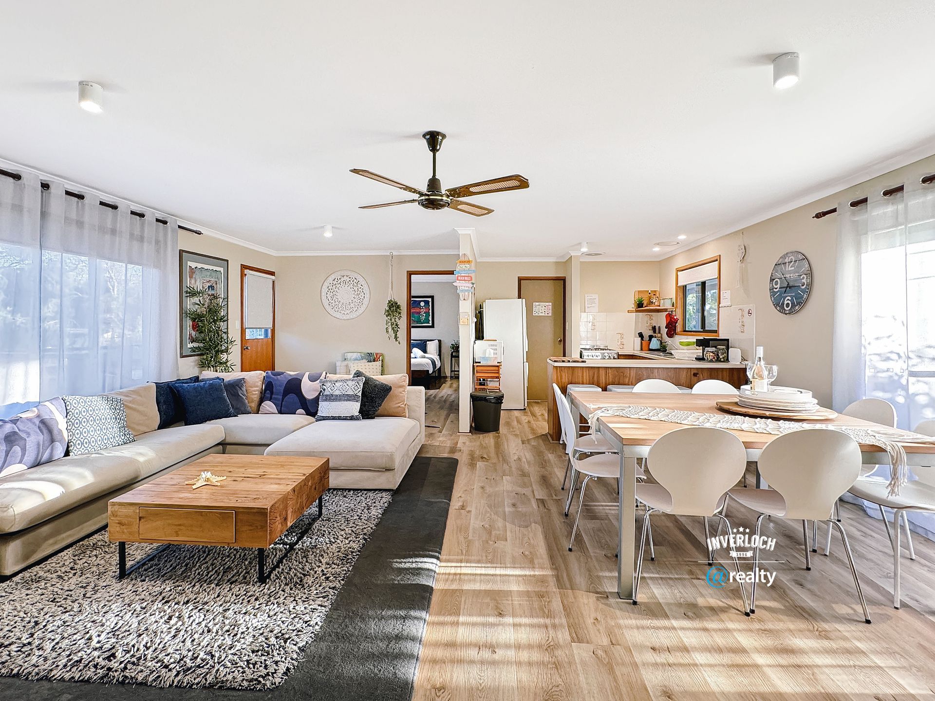 A living room filled with furniture and a ceiling fan.