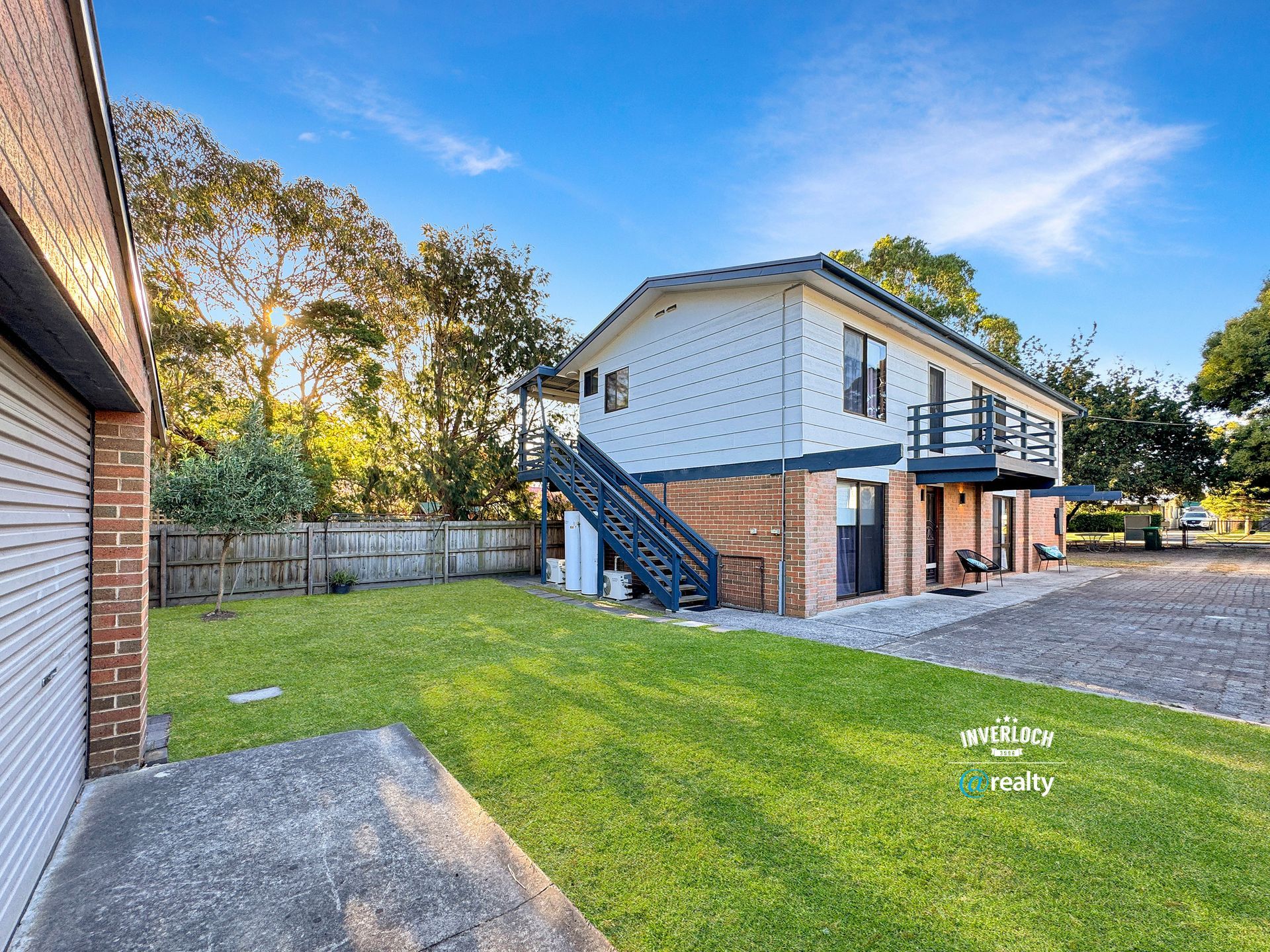 A large house with stairs leading up to the second floor is for sale.