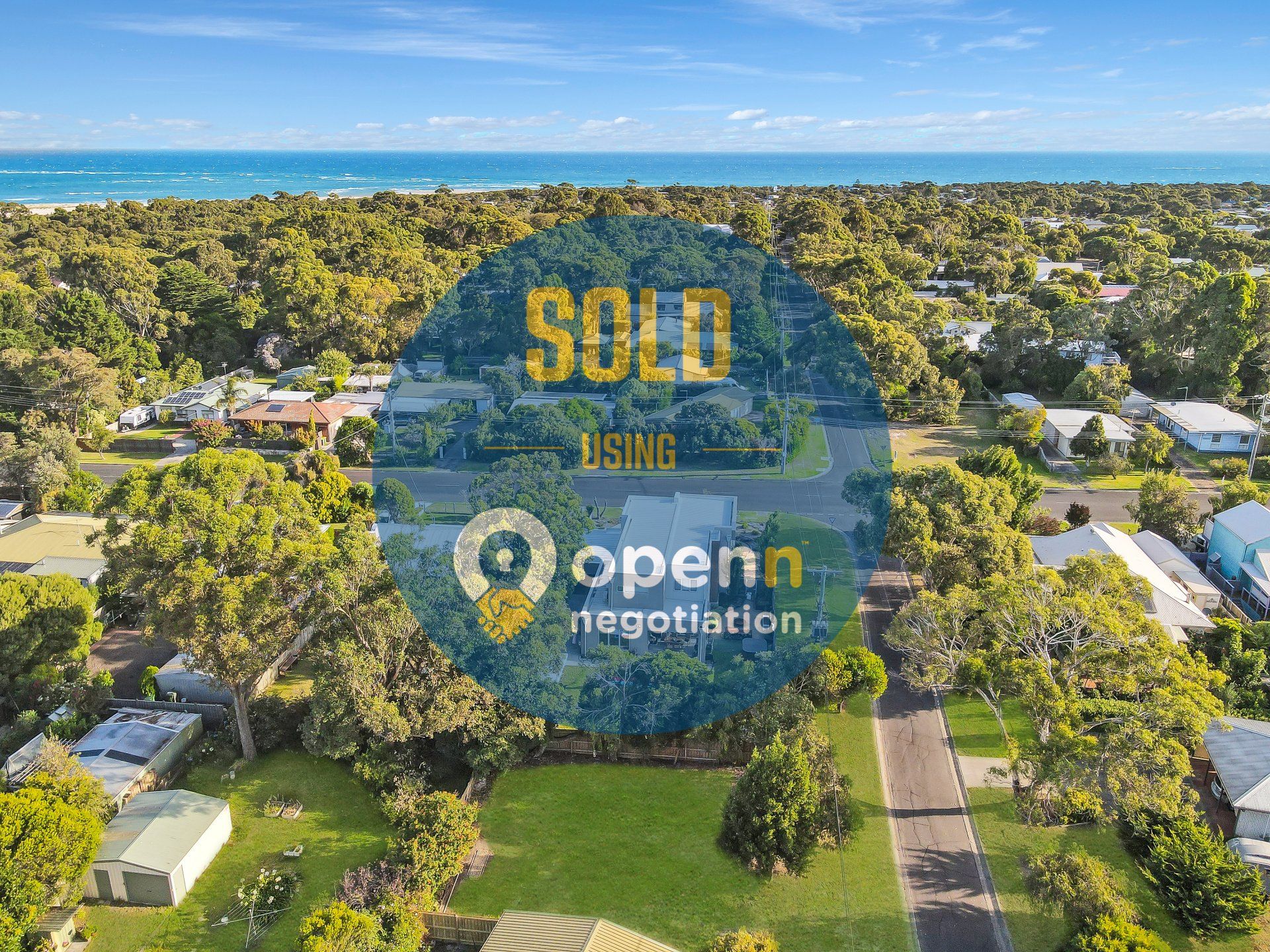 An aerial view of a residential area with a sold sign in the middle.