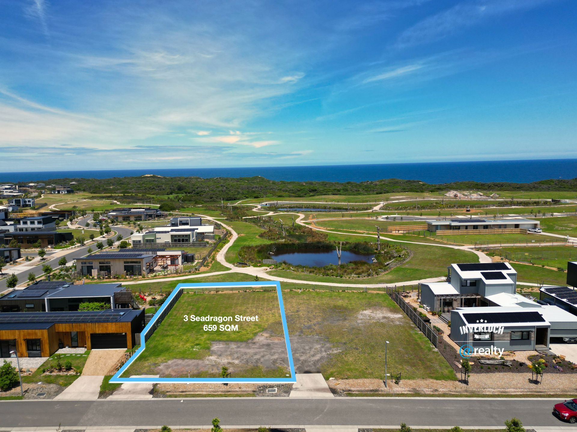An aerial view of a residential area with a lot in the middle of it.