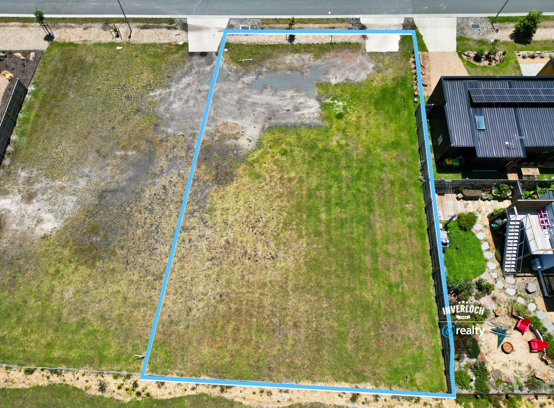 An aerial view of a residential area with a house in the background.