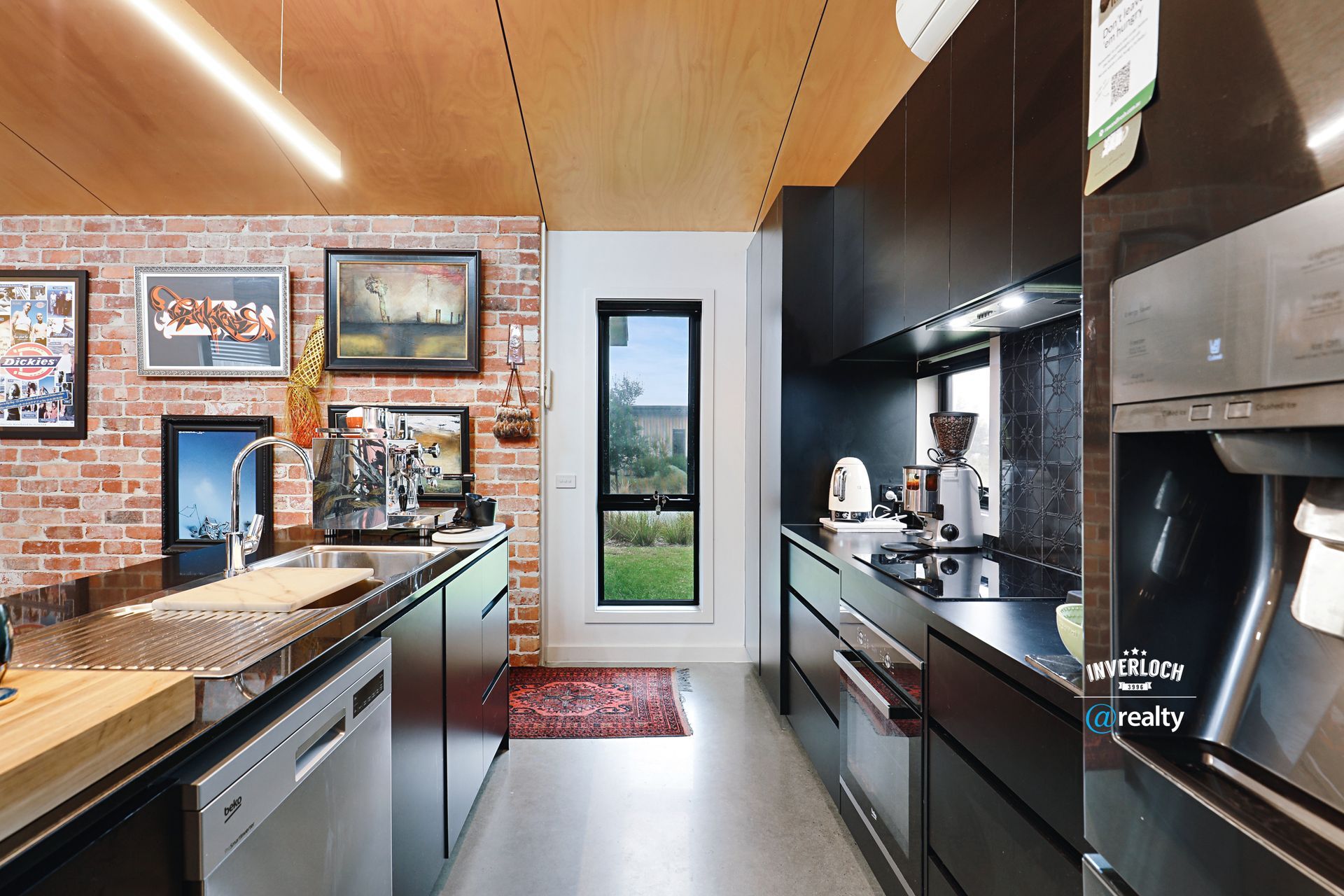A kitchen with stainless steel appliances and a brick wall