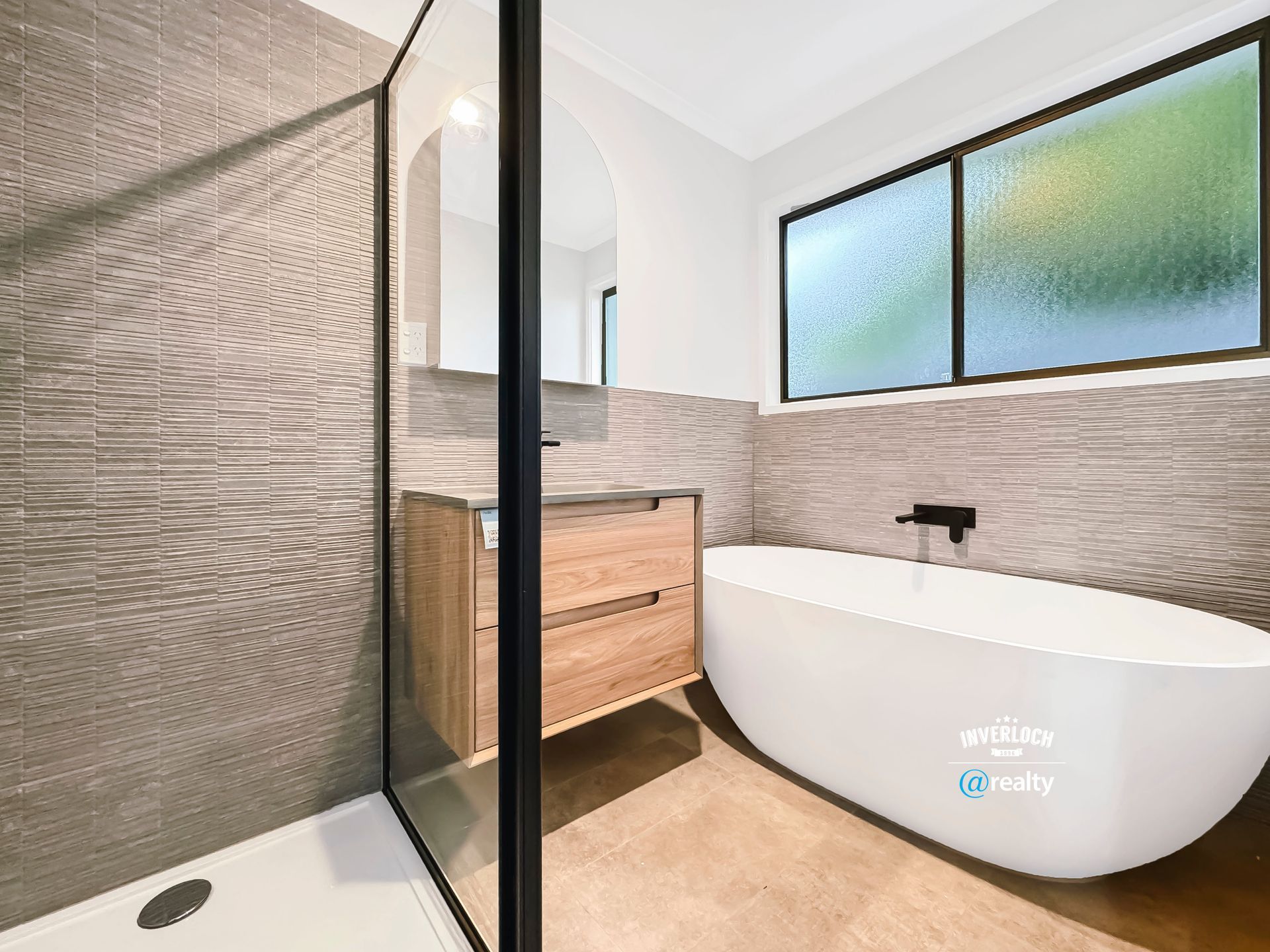 A bathroom with a bathtub , sink and shower.