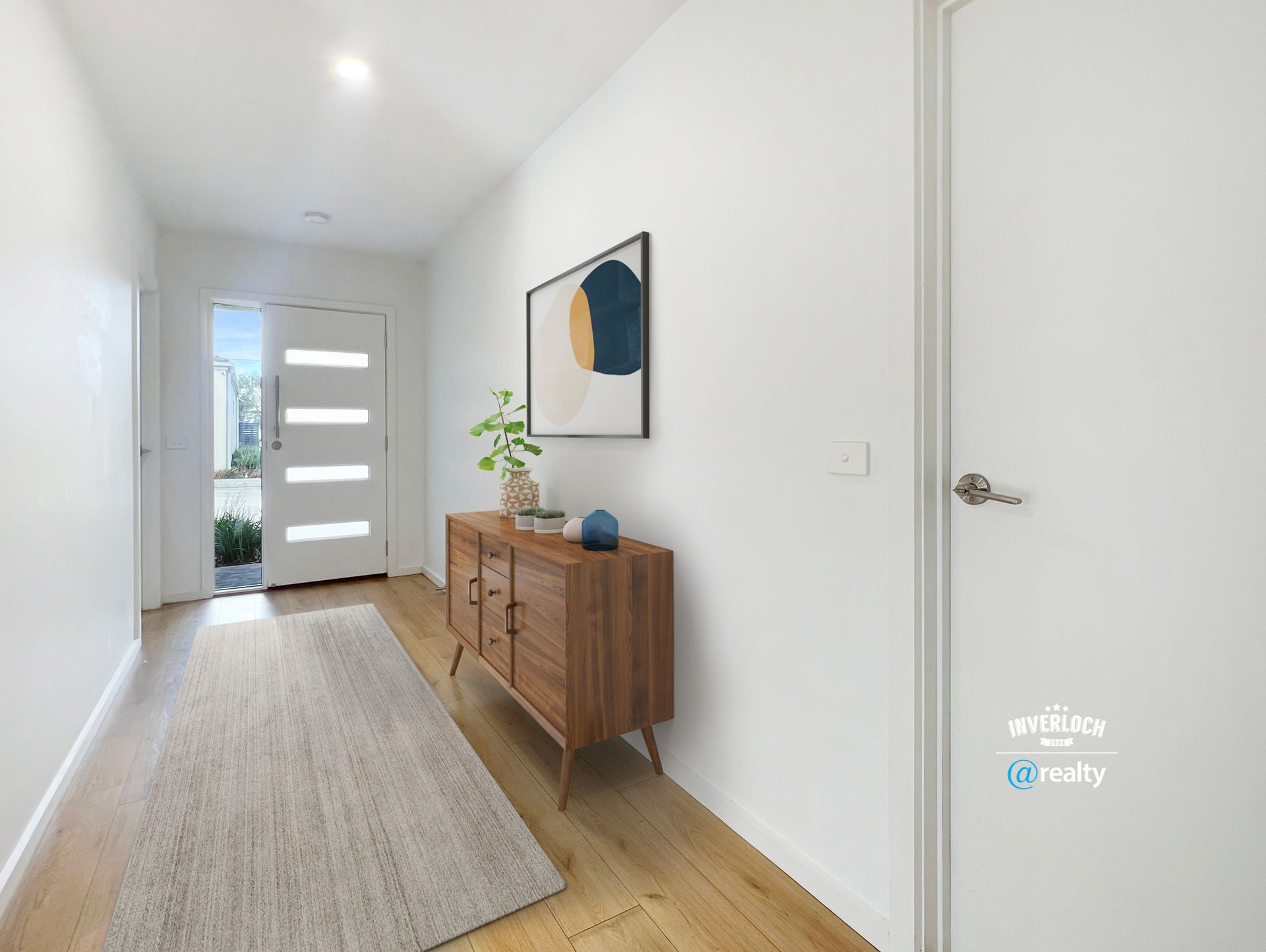 A hallway with a wooden dresser and a picture on the wall.