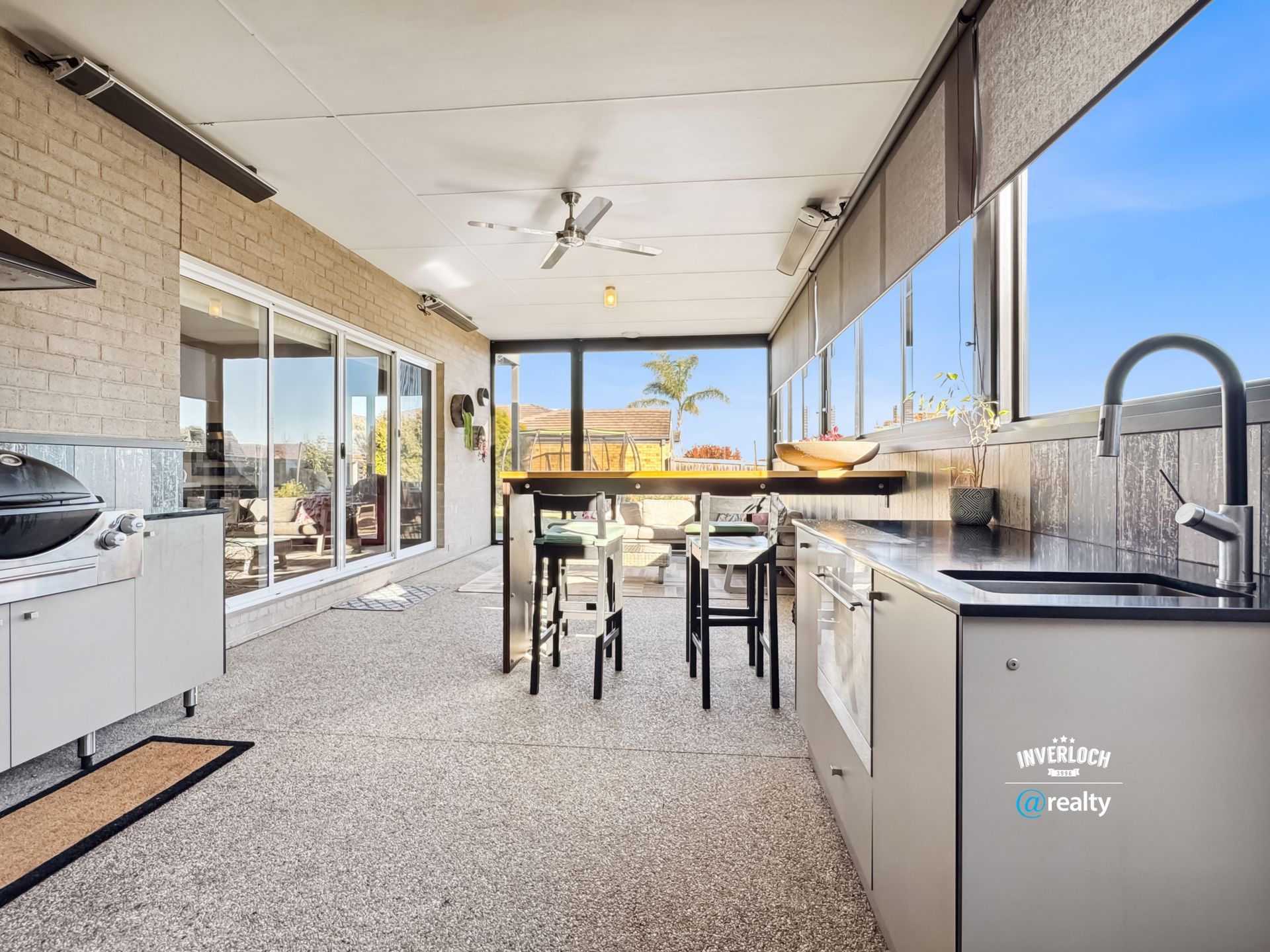 A kitchen with a lot of windows and a table and chairs.
