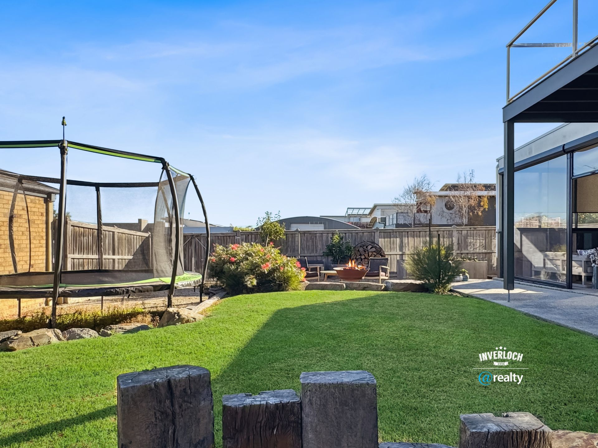 There is a trampoline in the backyard of a house.