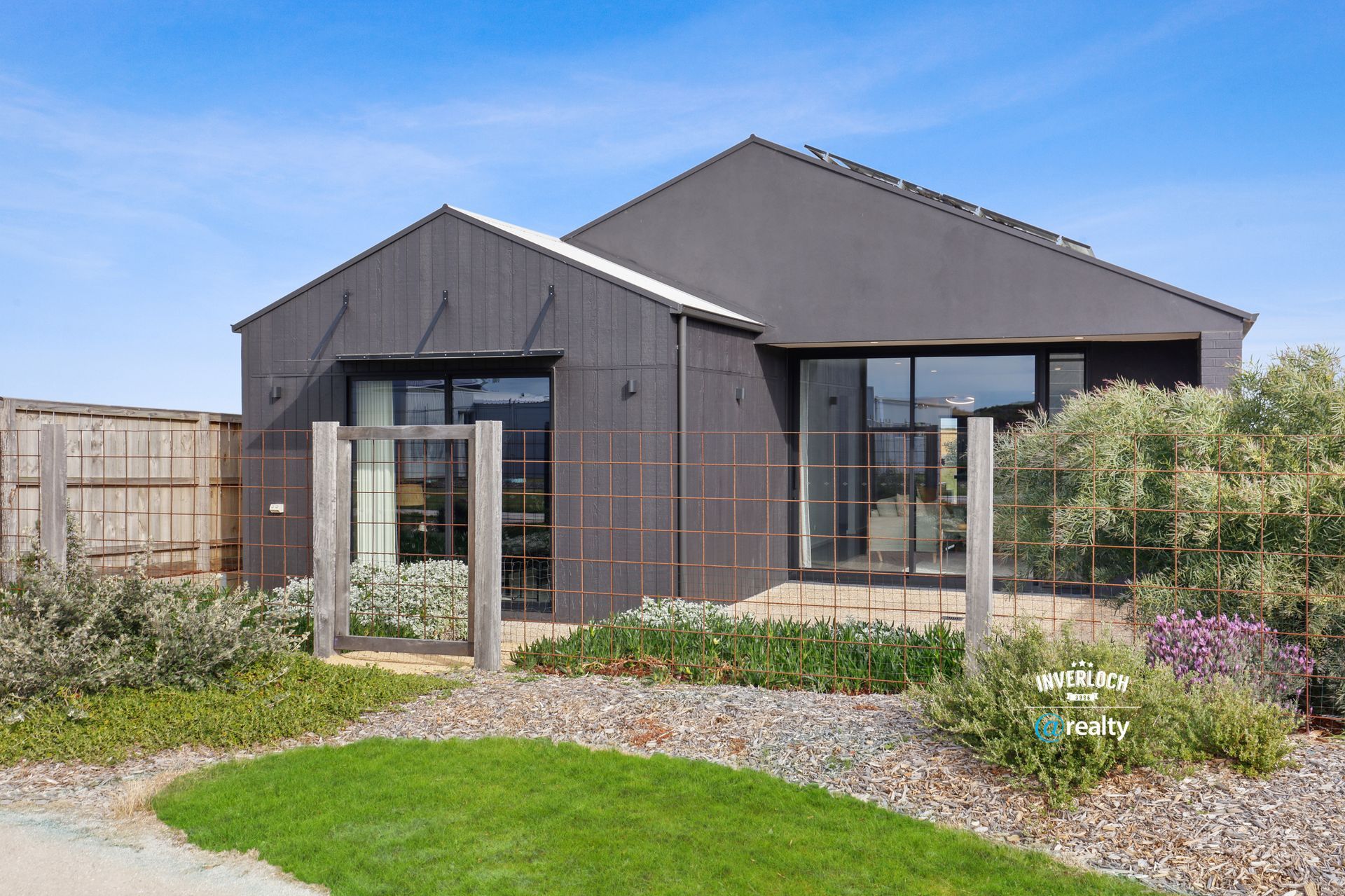A large house with a lot of windows is sitting on top of a lush green lawn.