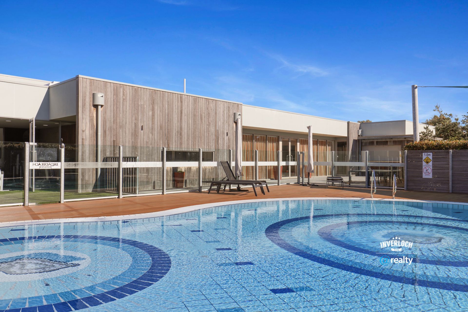 There is a large swimming pool in front of a building.