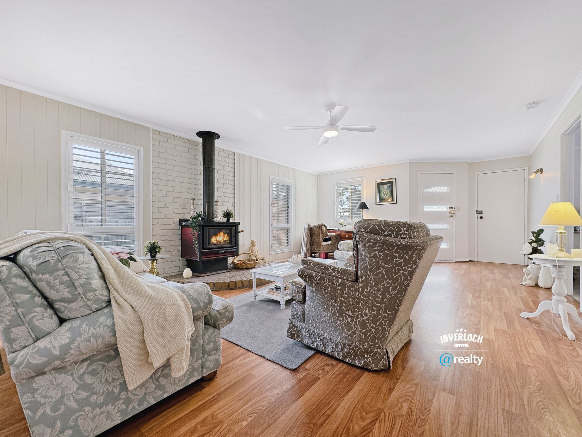 A living room filled with furniture and a wood stove.