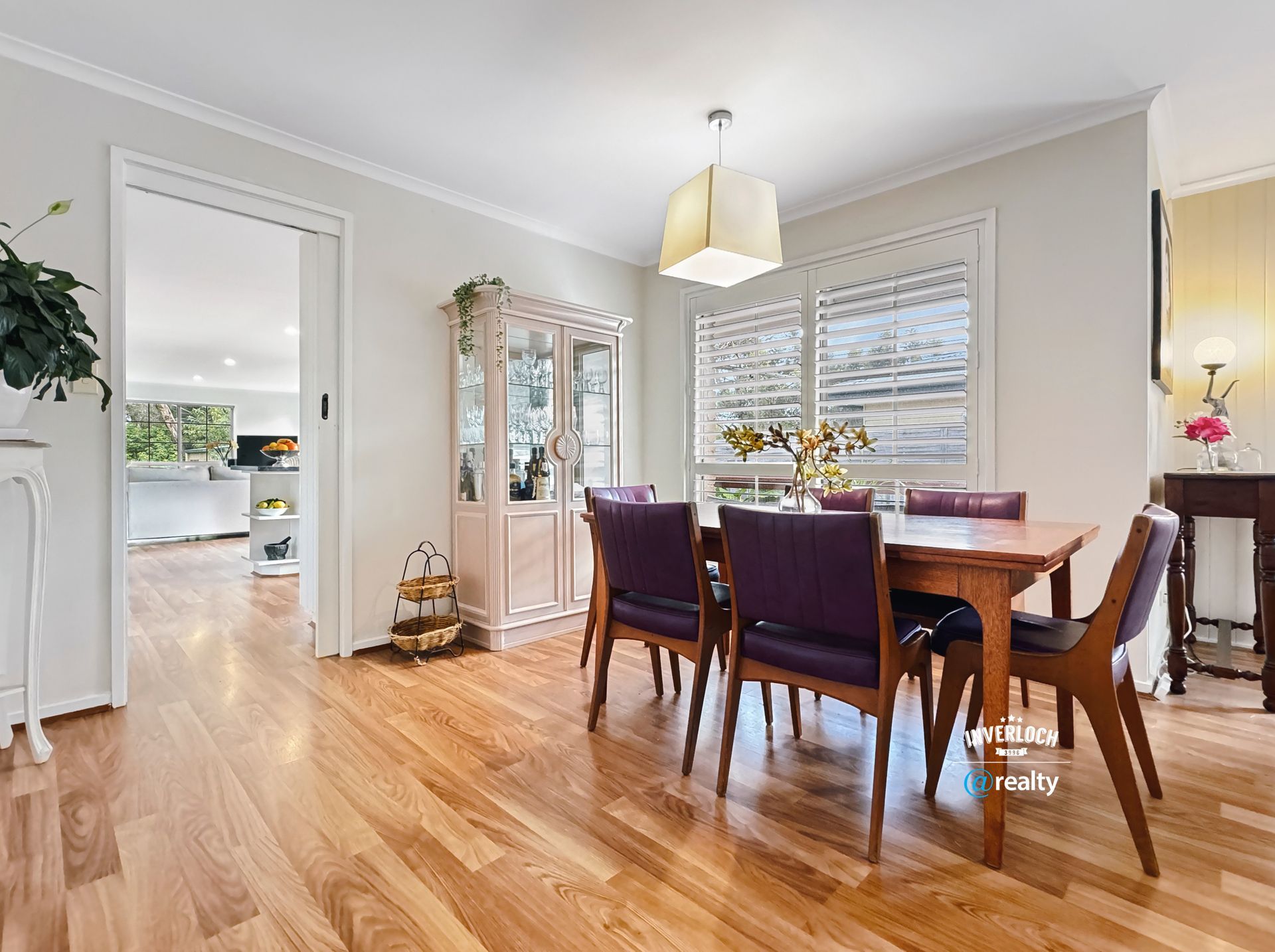 A dining room with hardwood floors and a table and chairs.