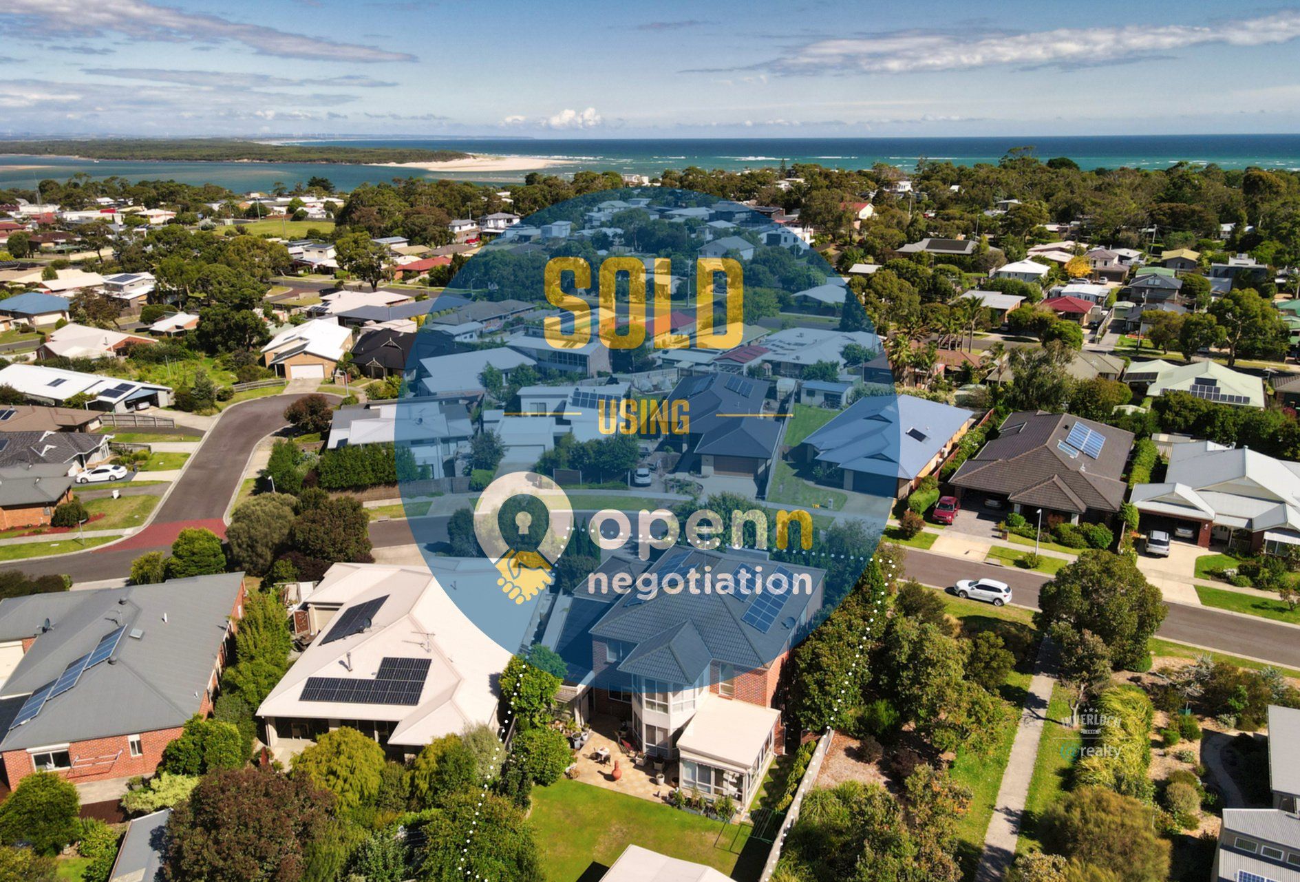 An aerial view of a residential area with a sold sign in the middle.