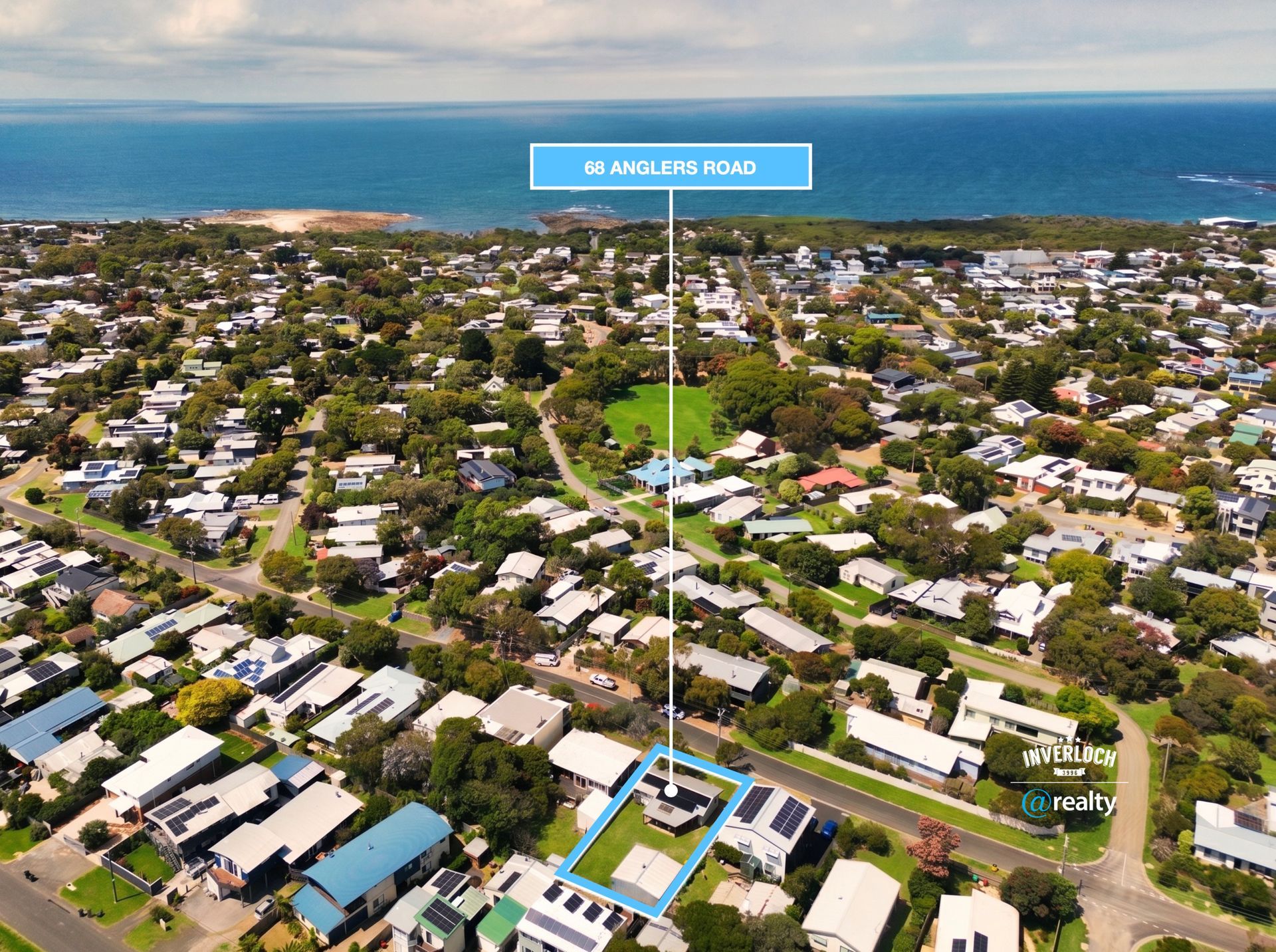 Aerial view of a coastal neighborhood with a highlighted property and ocean in the background