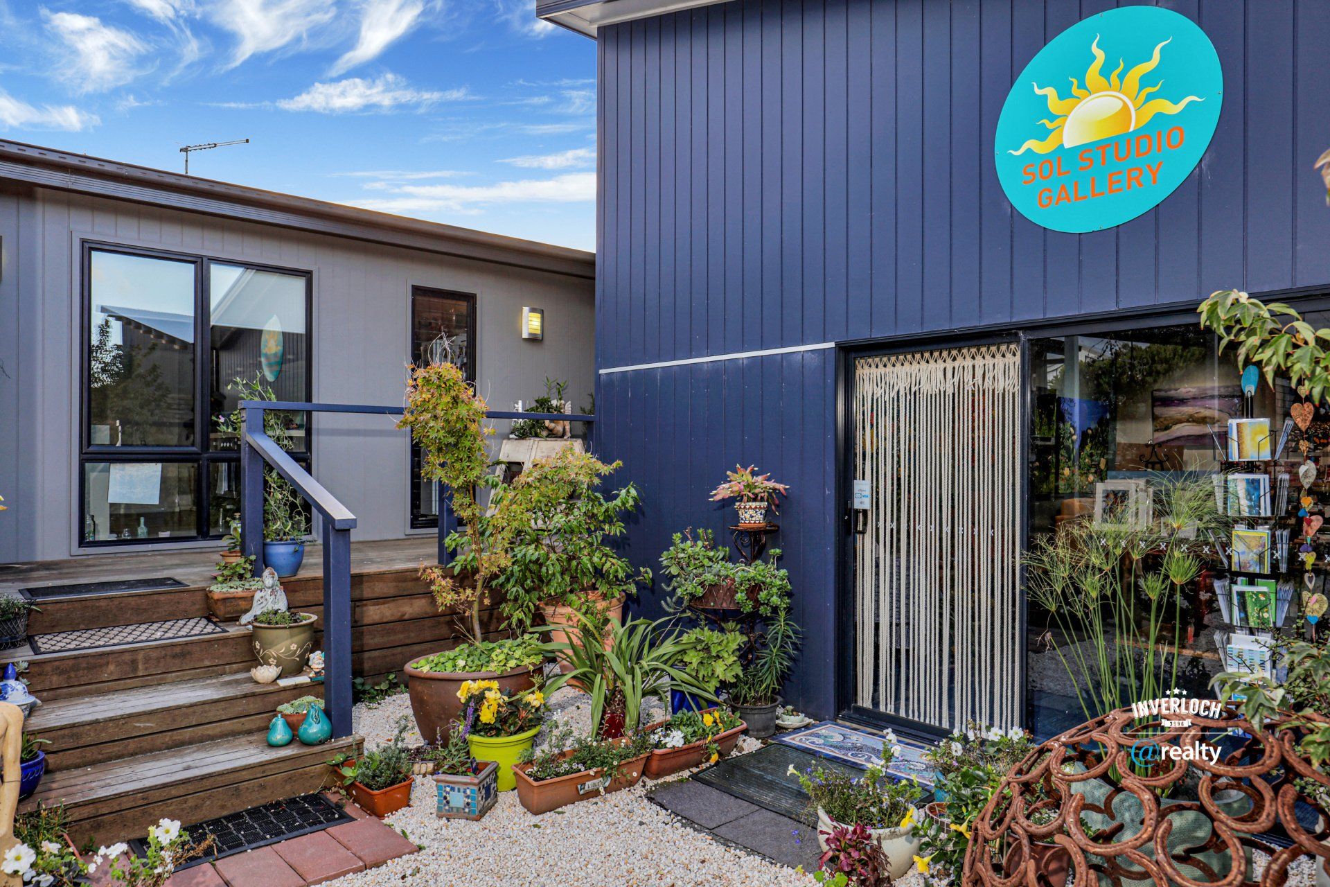 A house with a lot of potted plants in front of it.