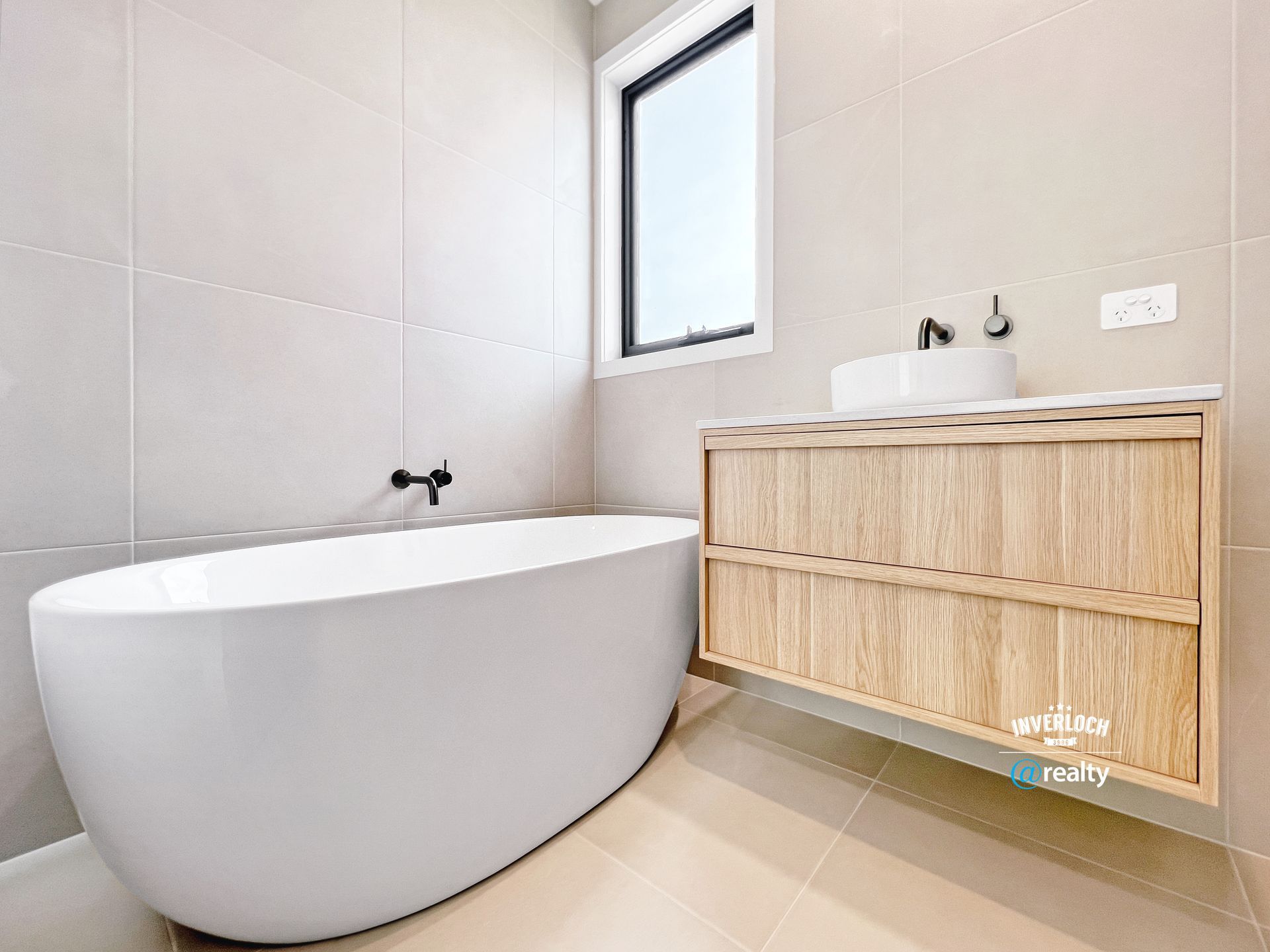 A bathroom with a bathtub , sink , and window.
