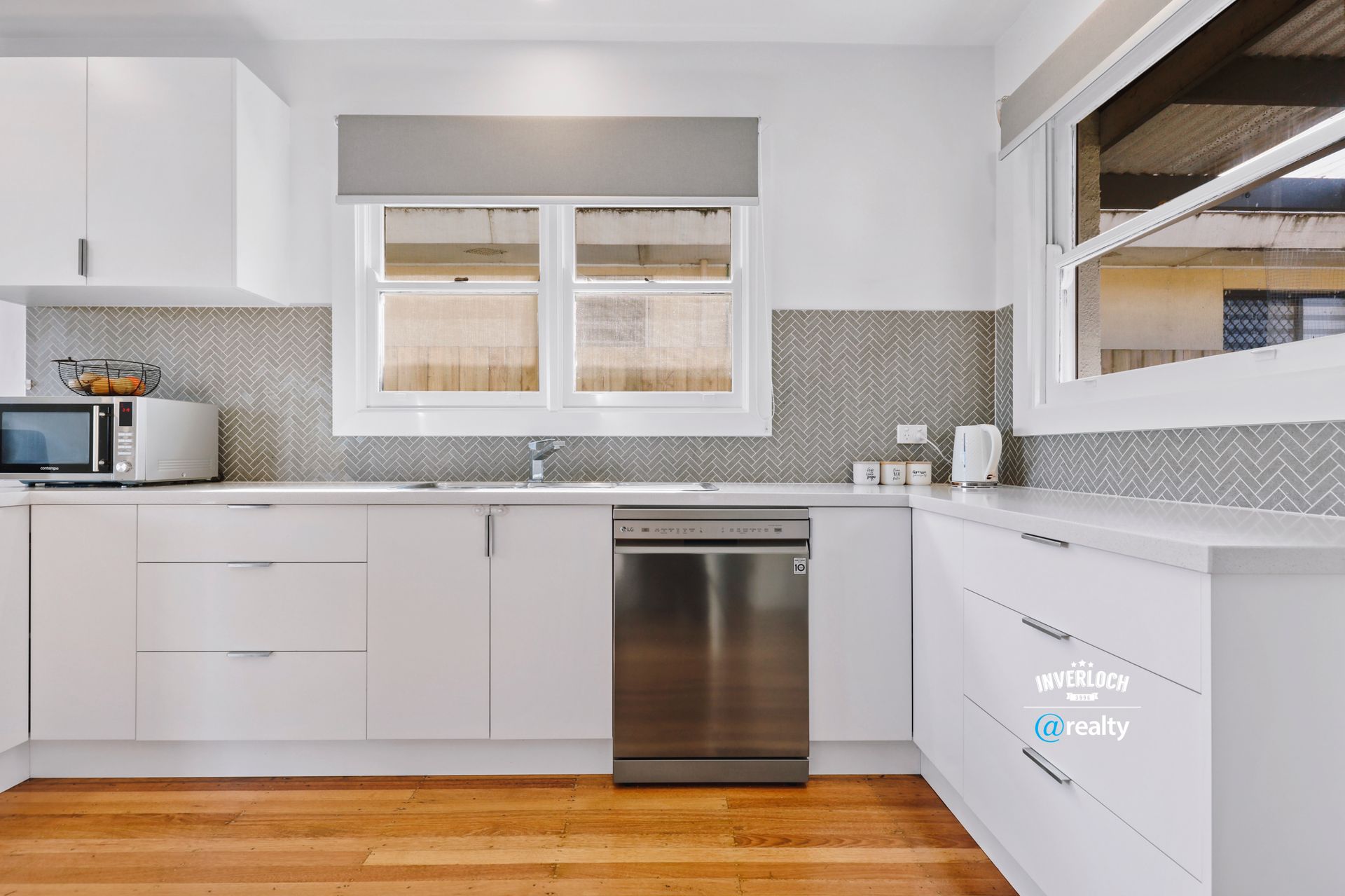 A kitchen with white cabinets and a stainless steel dishwasher