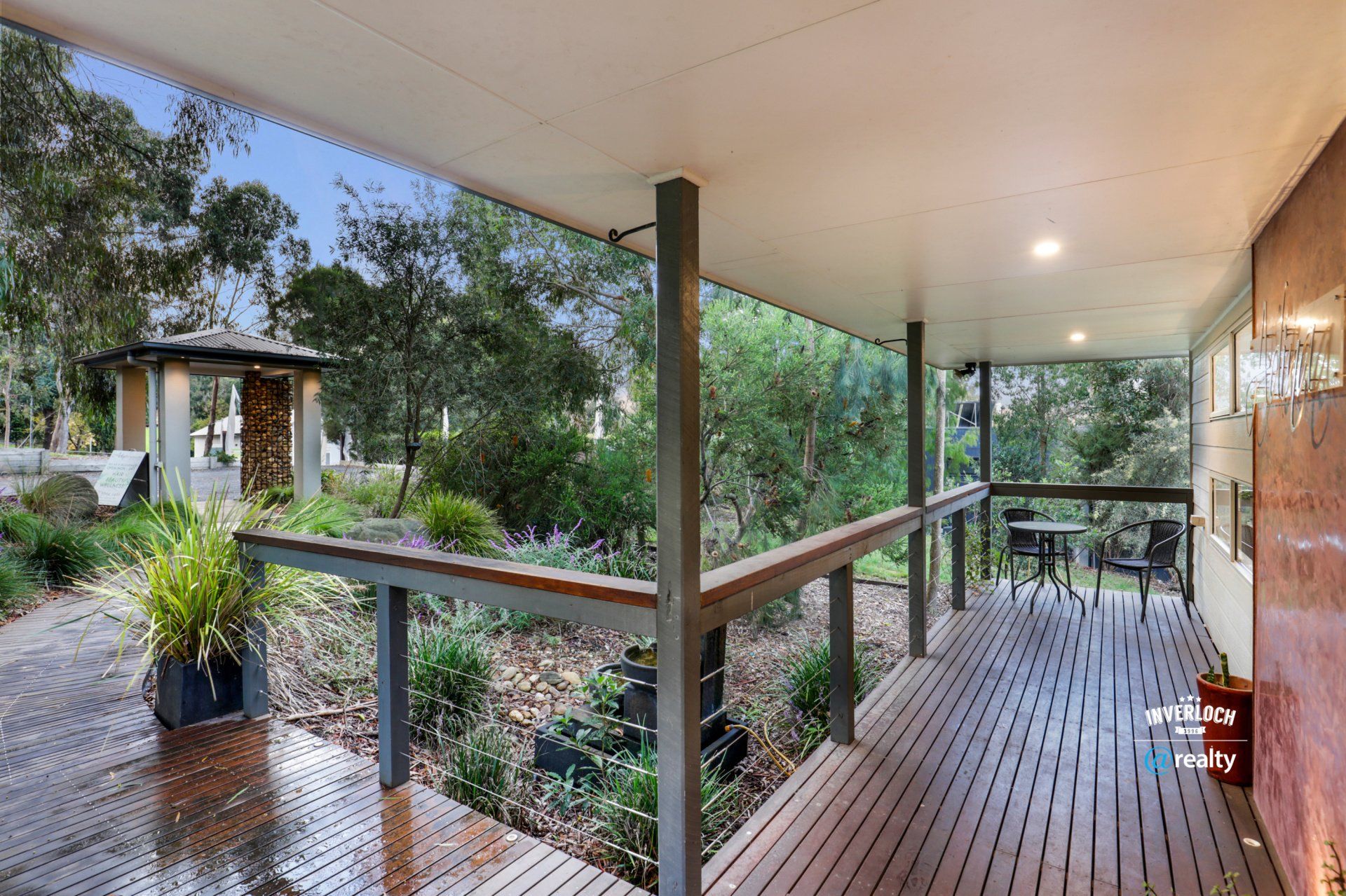 A large wooden deck with a gazebo in the background