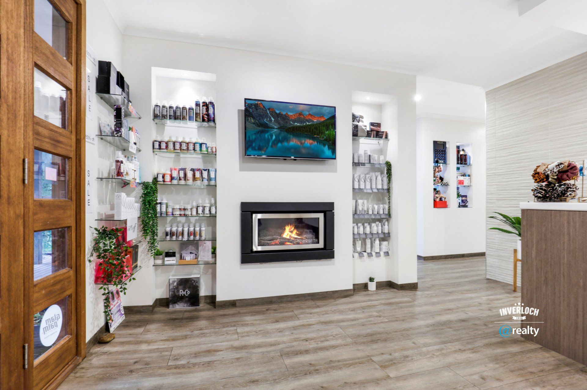 A living room with a fireplace and a television on the wall.