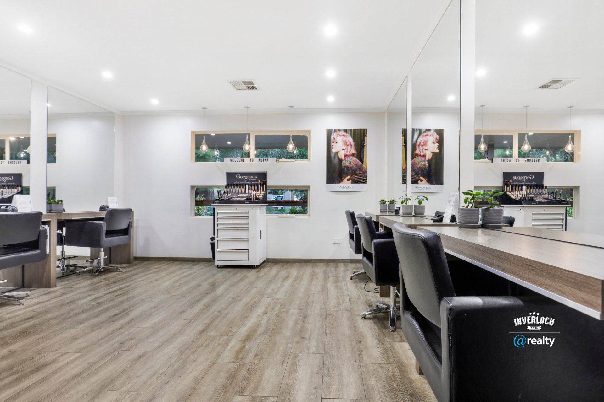A large room with a lot of chairs and tables in a hair salon.