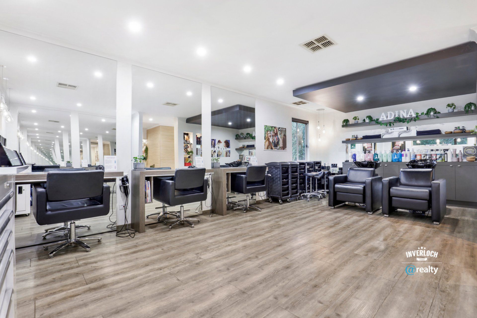 A large hair salon with lots of chairs and tables.