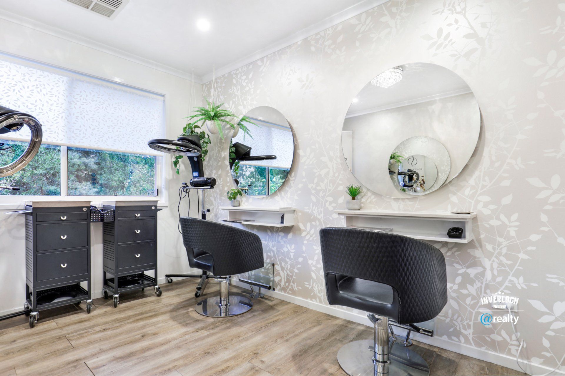 A hair salon with two chairs and two mirrors.