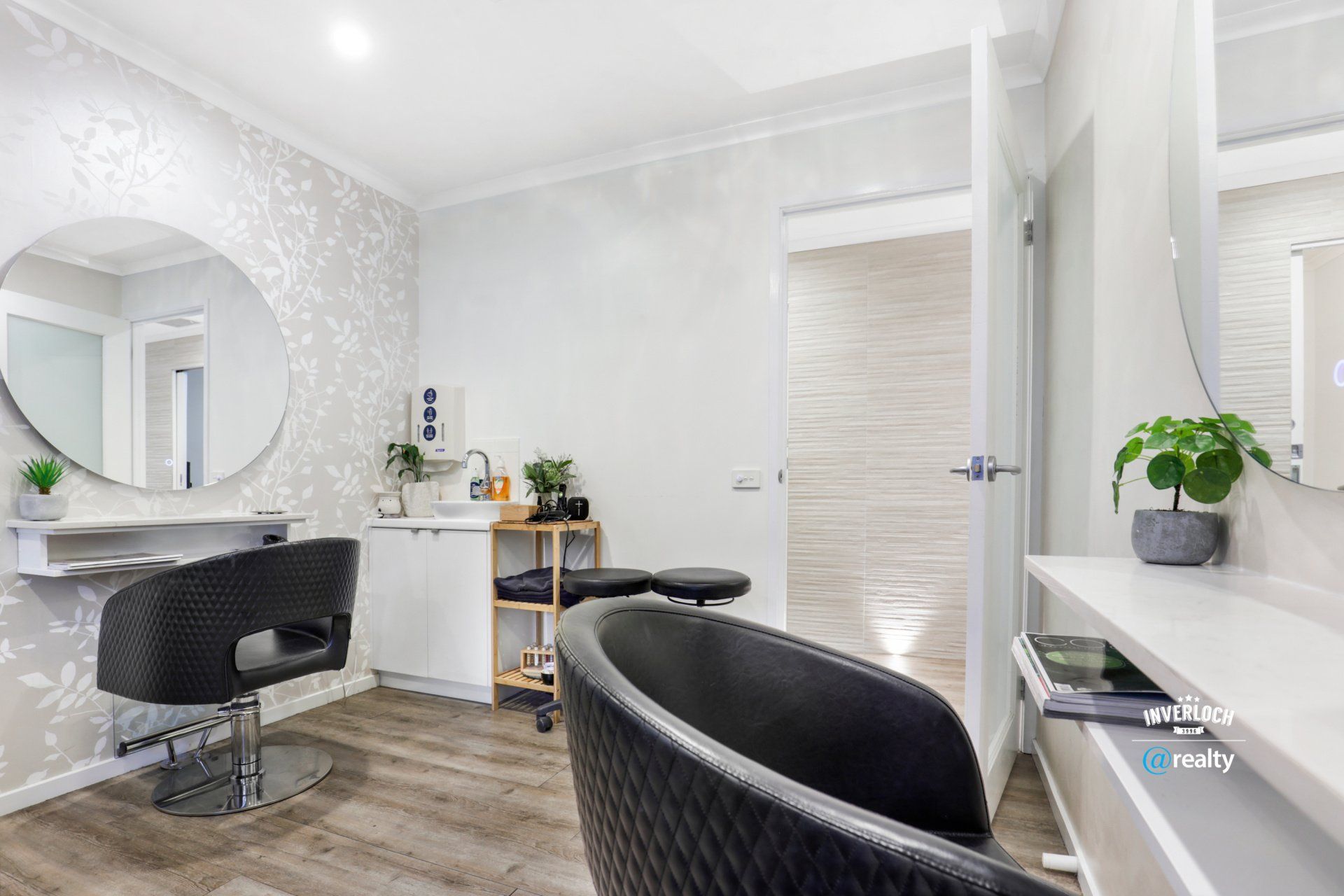 A hair salon with two chairs and a mirror.