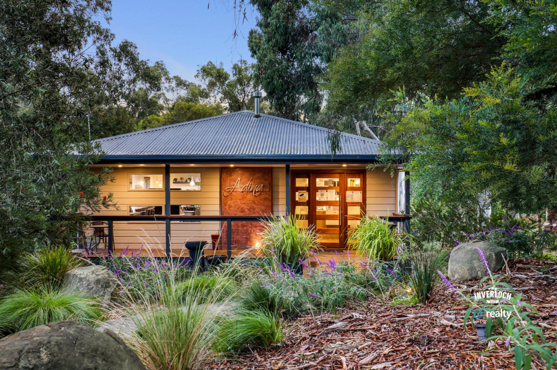 A house with a roof that is surrounded by trees and plants.