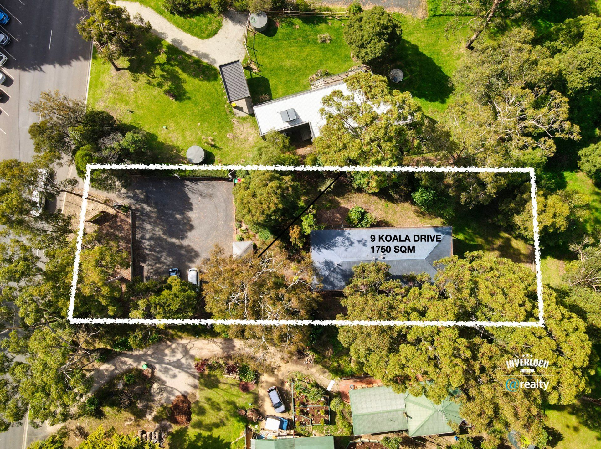 An aerial view of a house surrounded by trees and grass