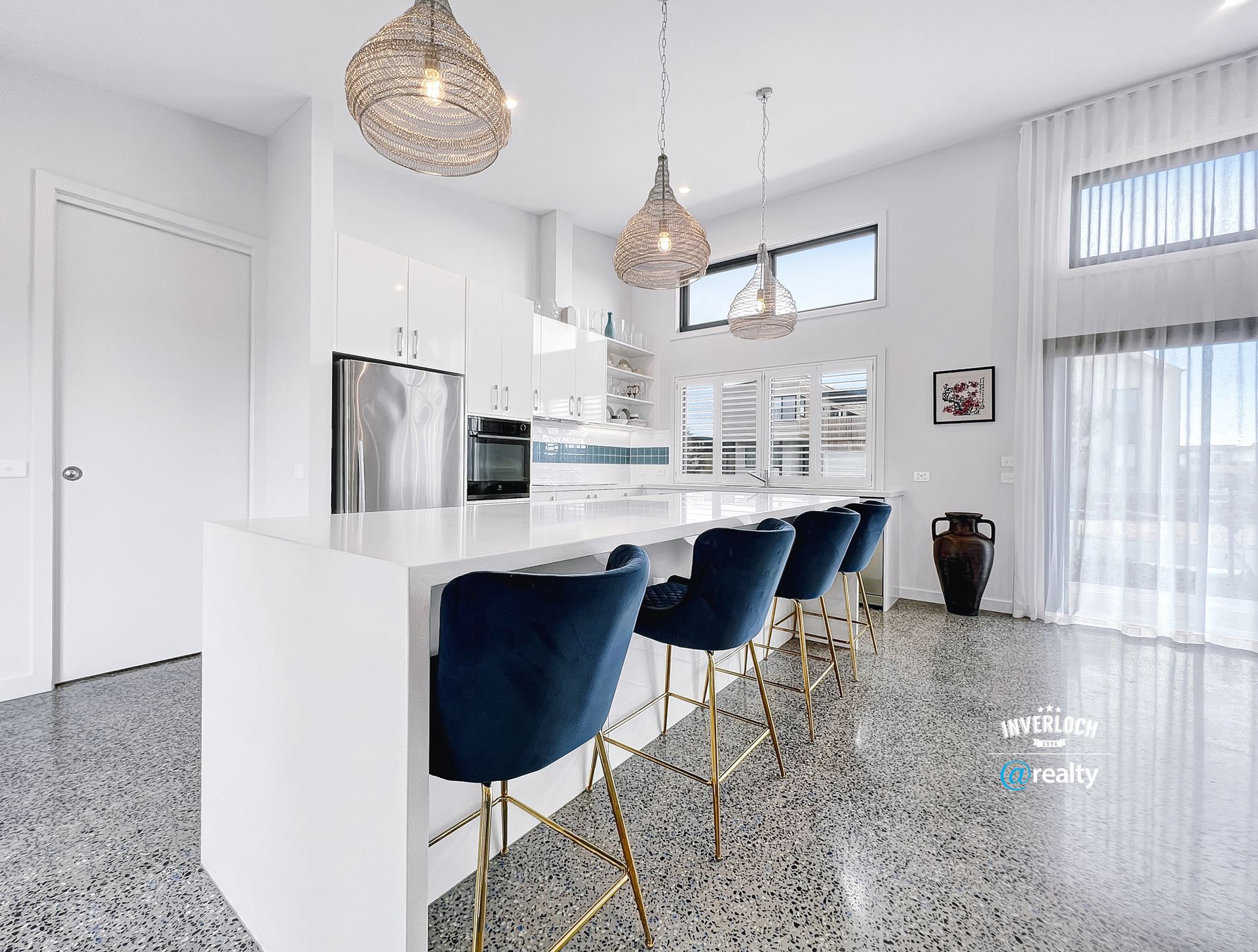 A kitchen with a white counter top and blue chairs.