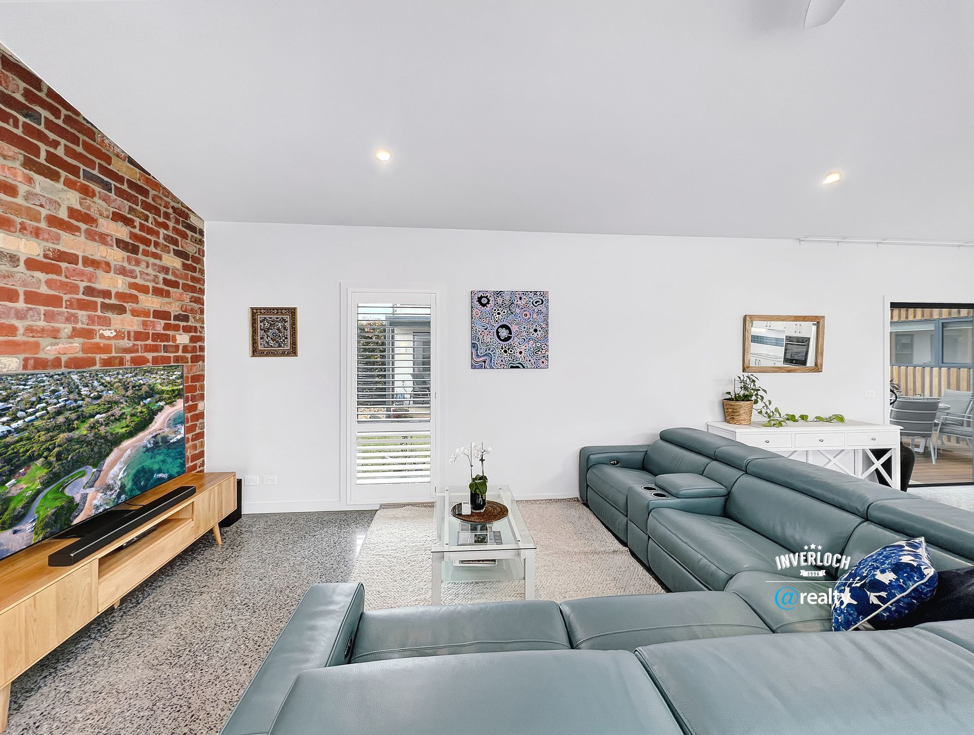 A living room with a large couch and a flat screen tv.