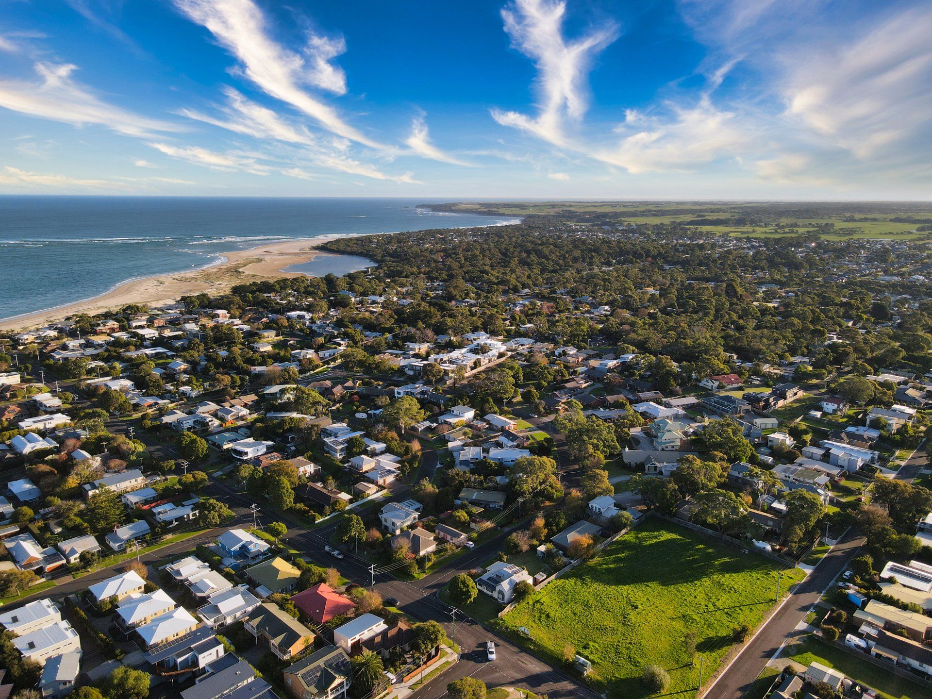 An aerial view of a residential area next to the ocean.