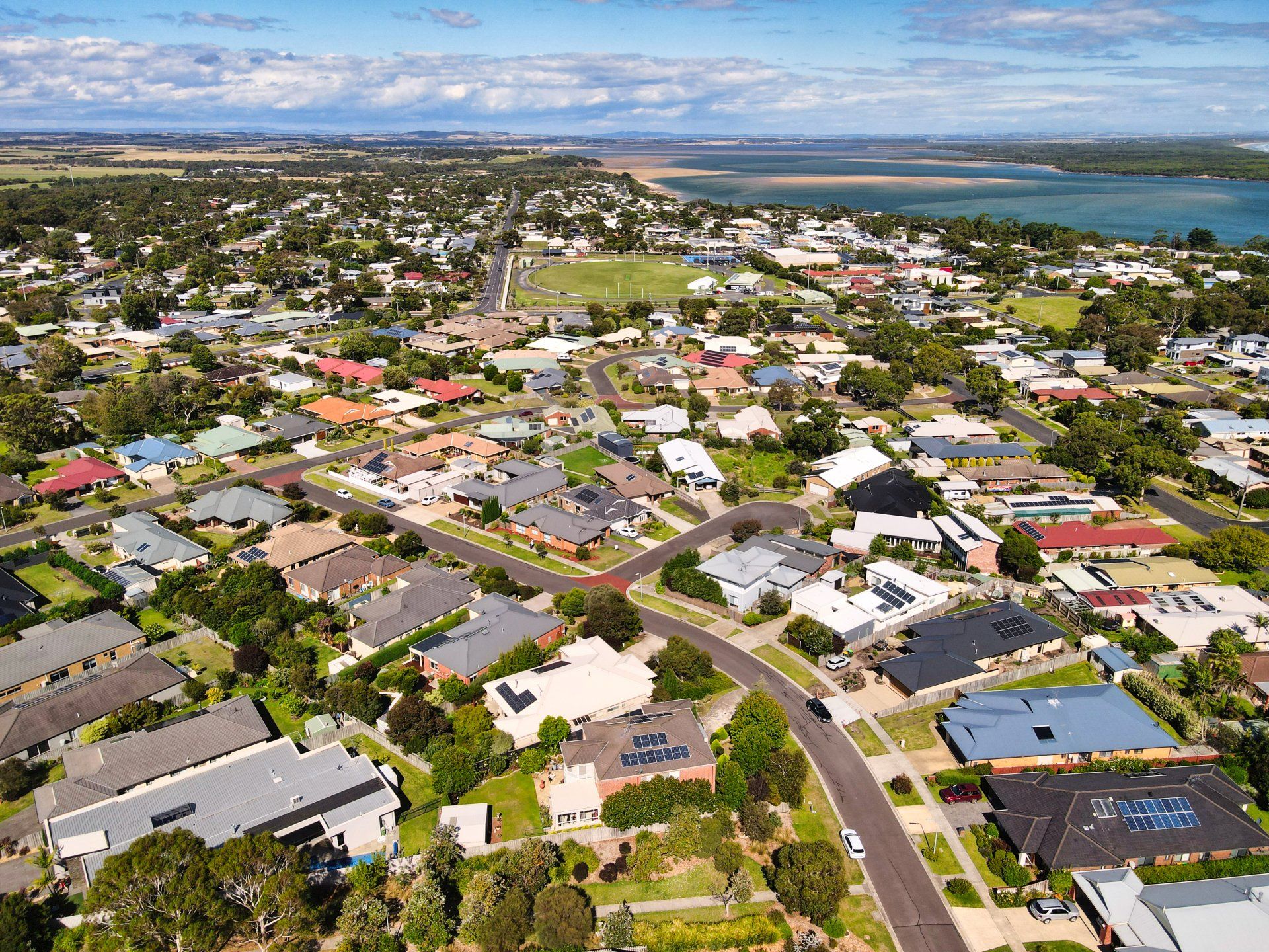 An aerial view of a residential area with a lake in the background.