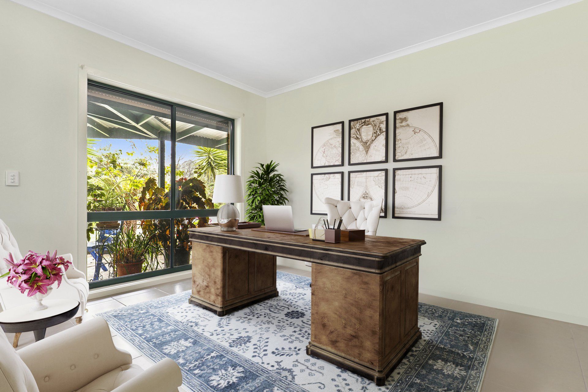A living room with a desk , chair , table and window.