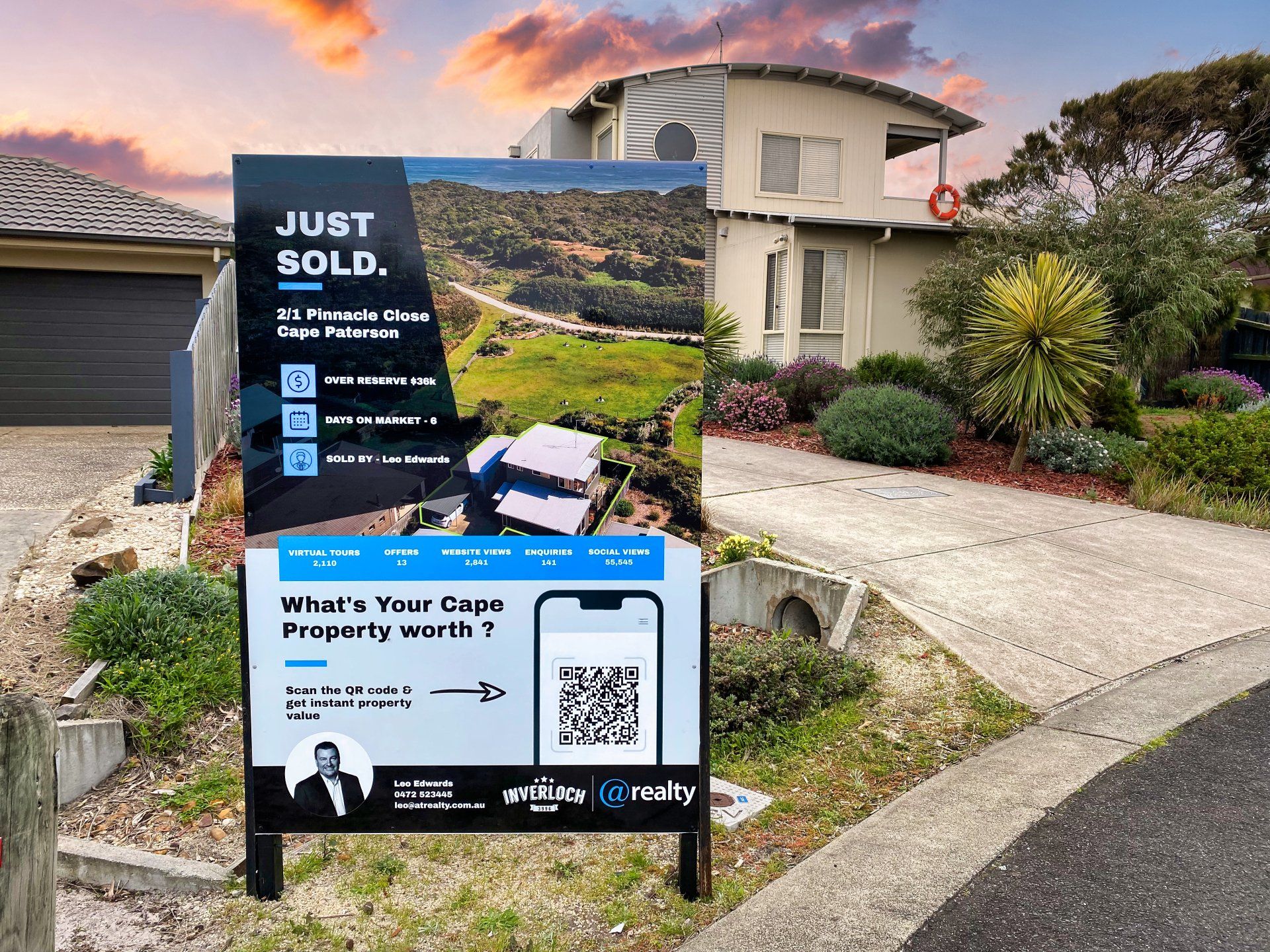A just sold sign is in front of a house.