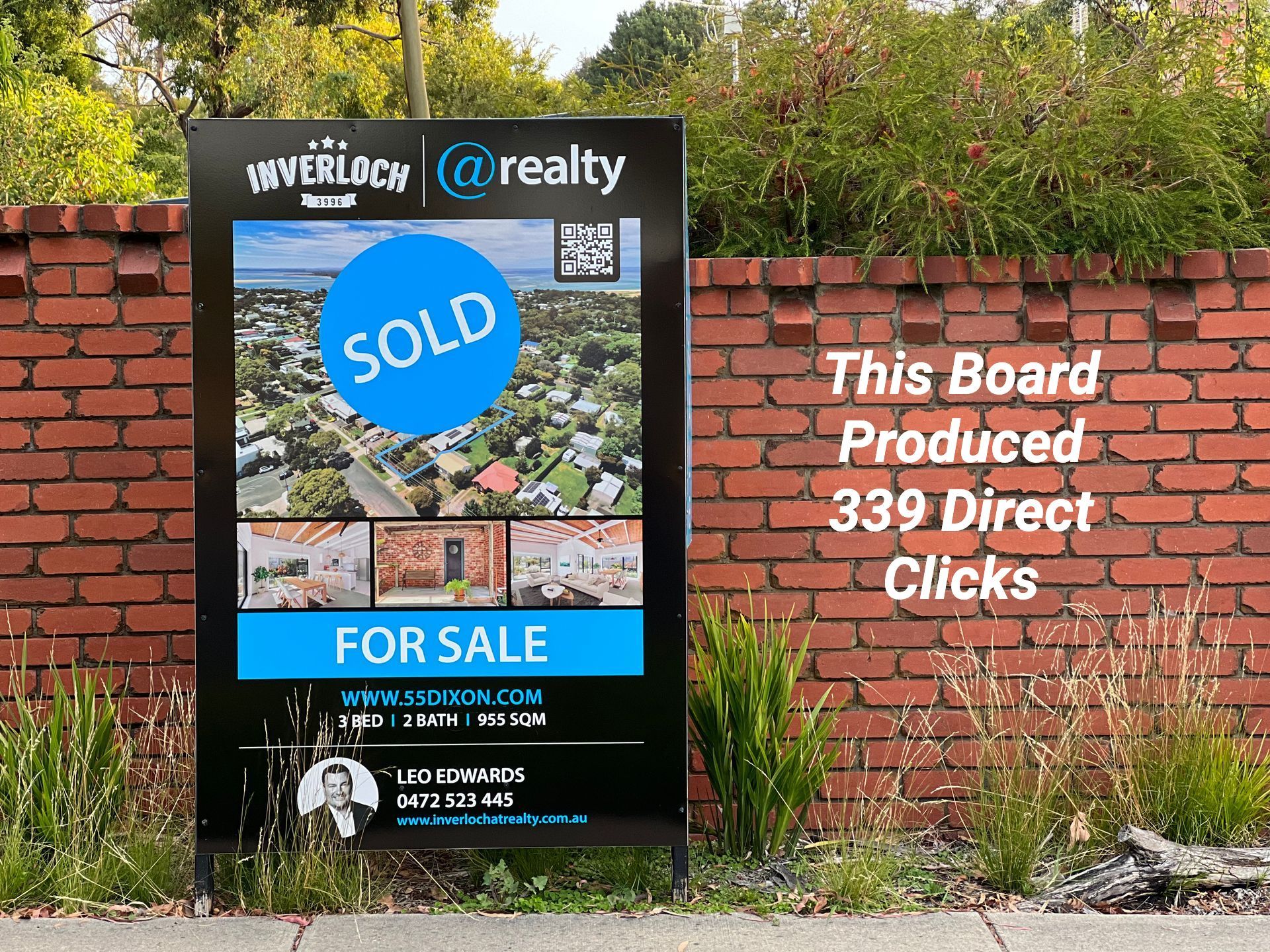 A sold sign is hanging on a brick wall