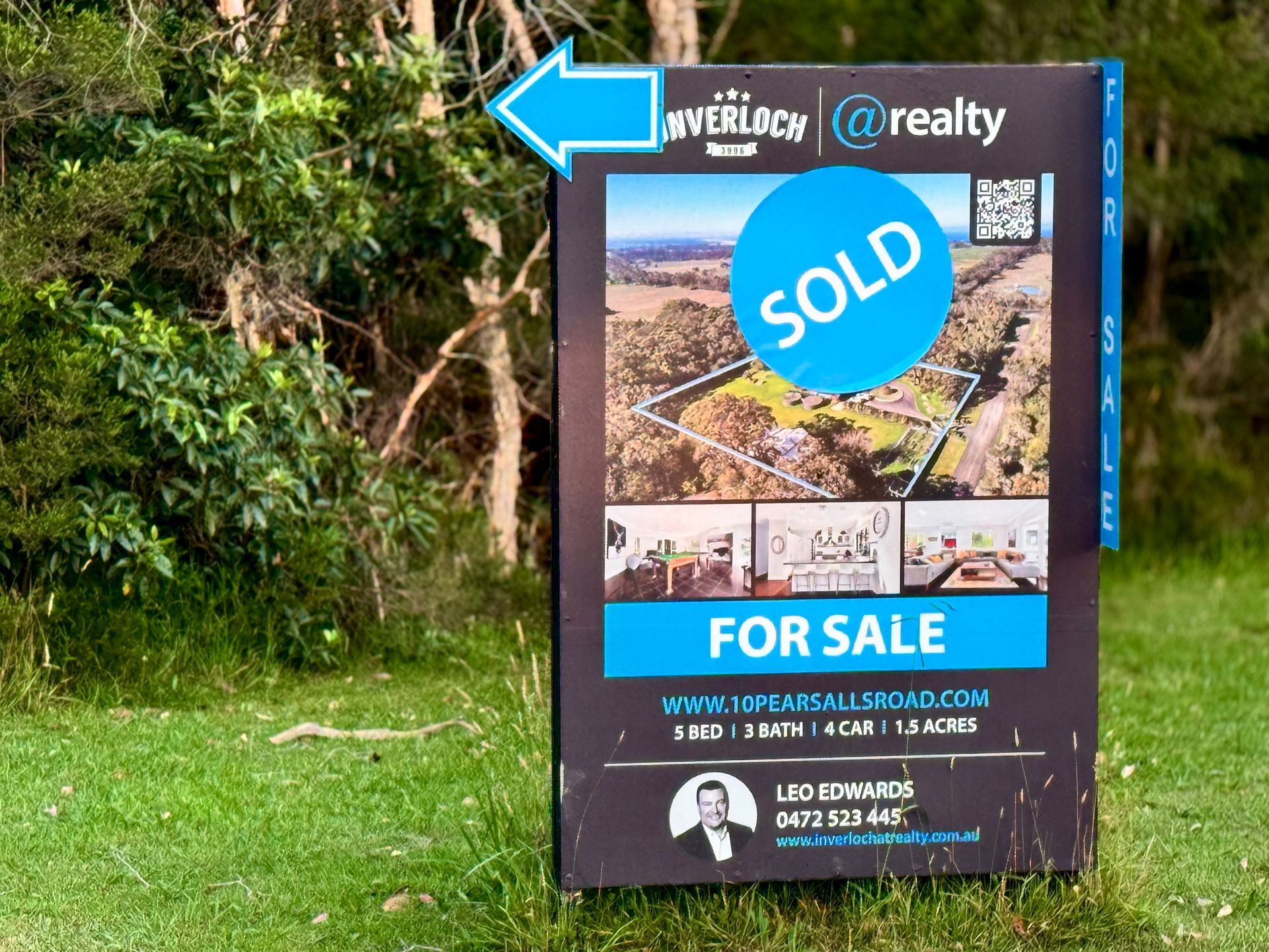 Real estate sign in a grassy area, 
