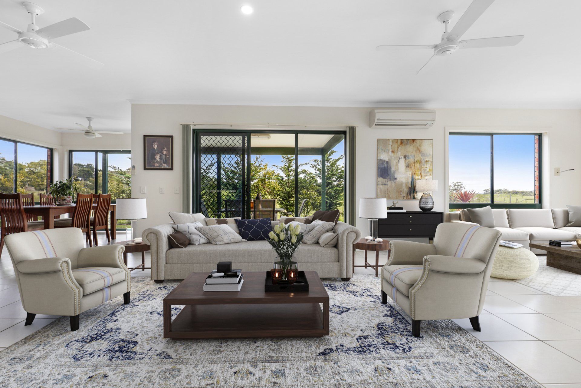 A living room with a lot of furniture and a ceiling fan