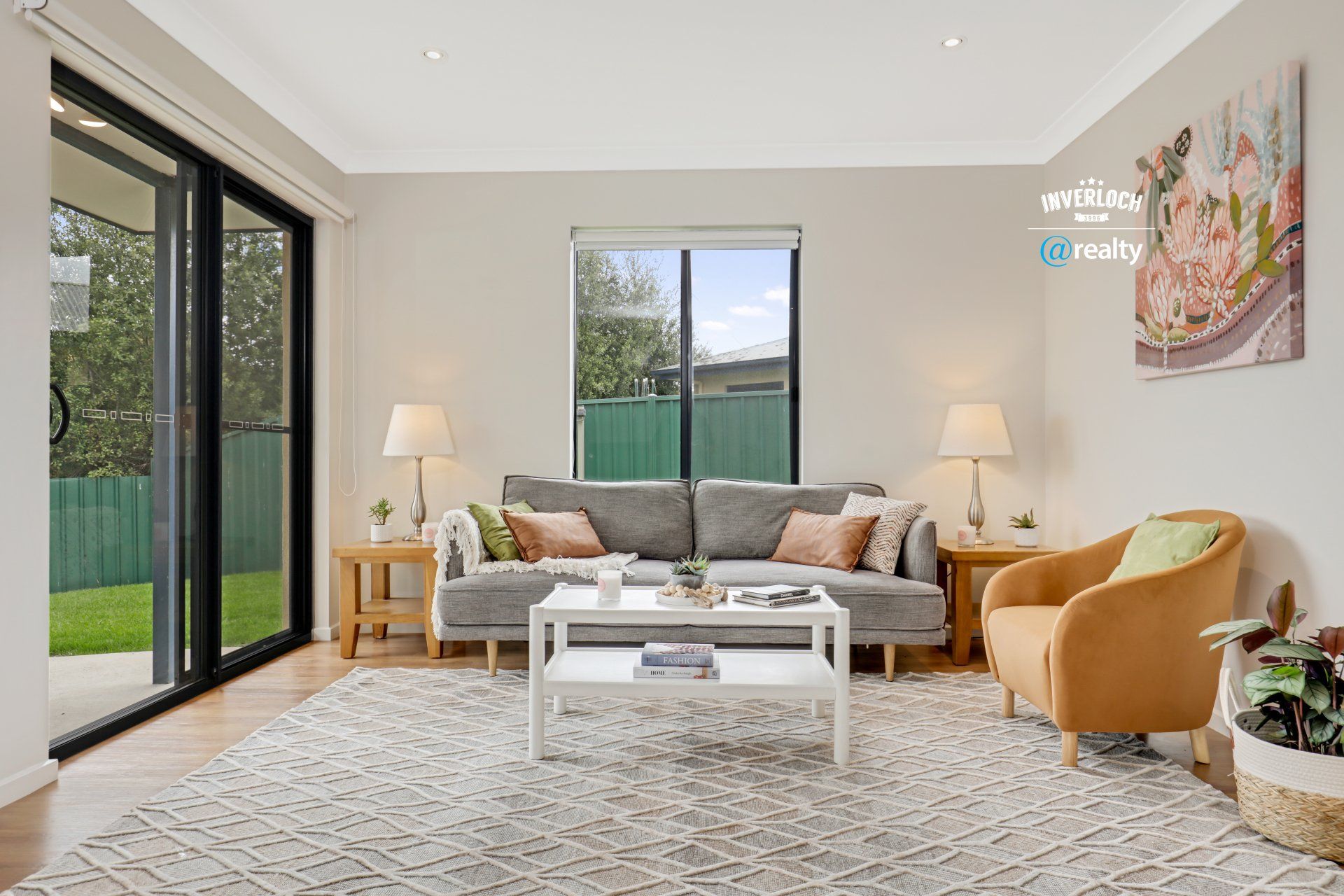 A living room with a couch , chair , coffee table and sliding glass doors.