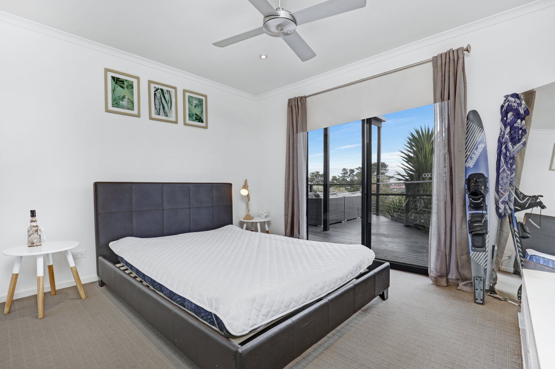 A bedroom with a large bed and a ceiling fan.