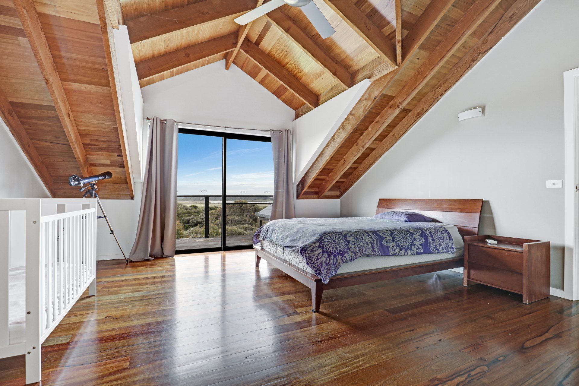 A bedroom with a wooden ceiling and a bed