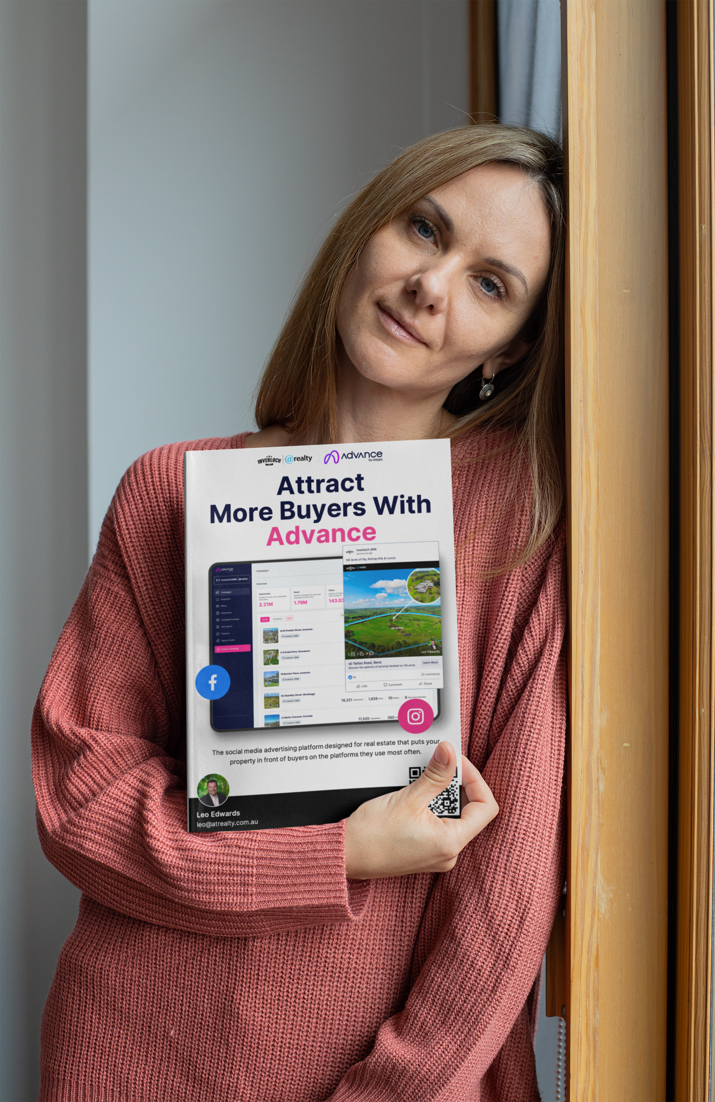 A woman in a pink sweater is holding a book.