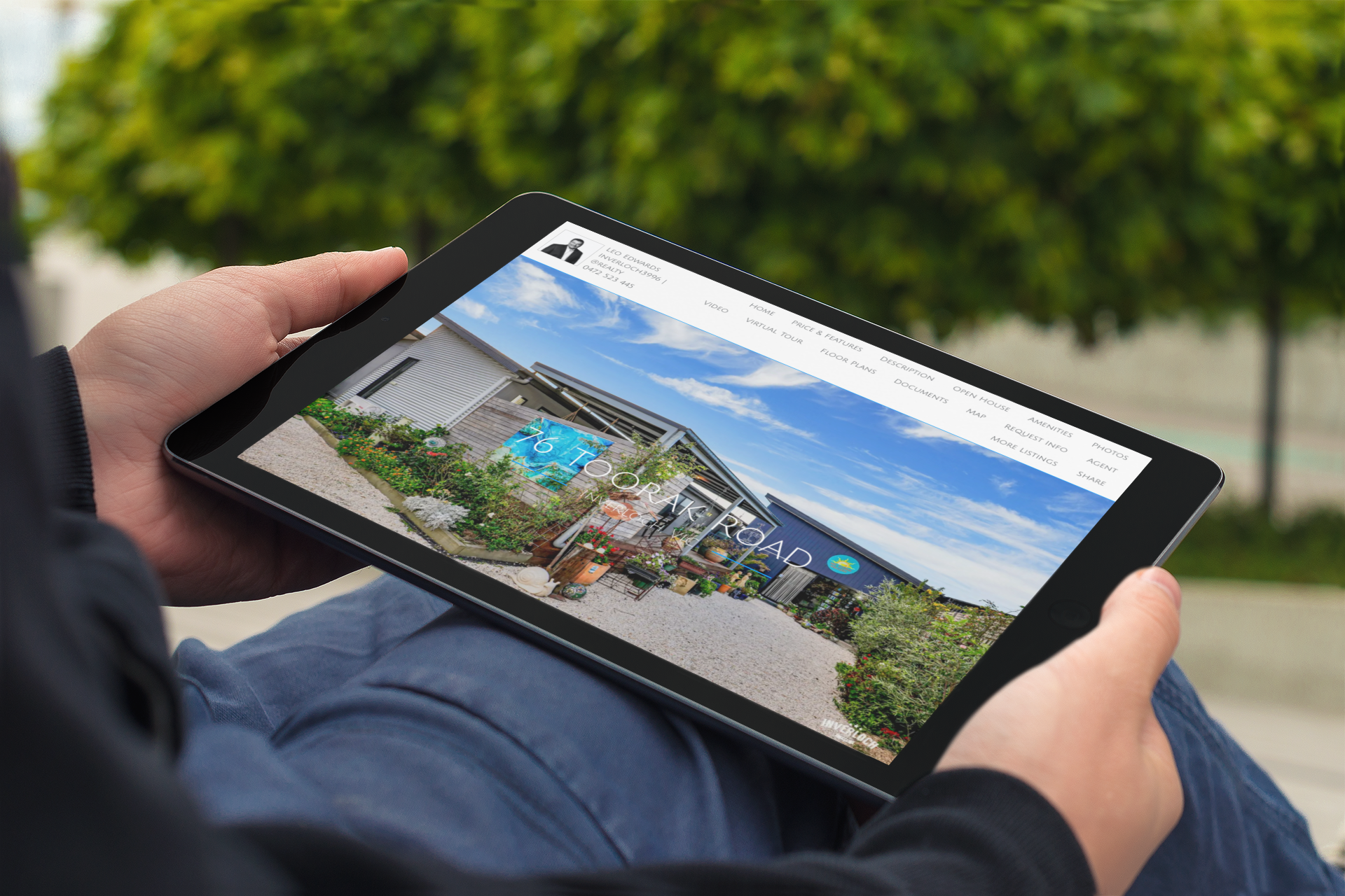 A person is holding a tablet with a picture of a house on it.